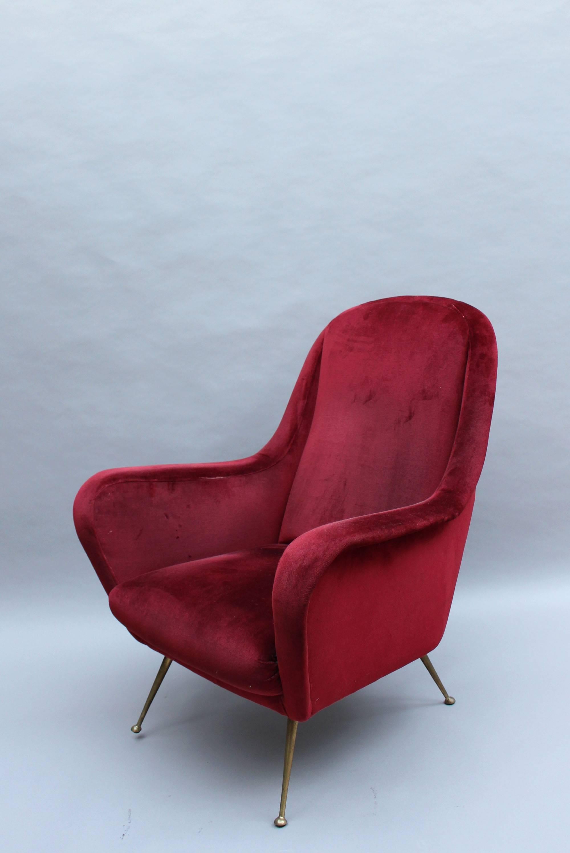 A fine 1970's Italian red velvet armchair with brass legs.