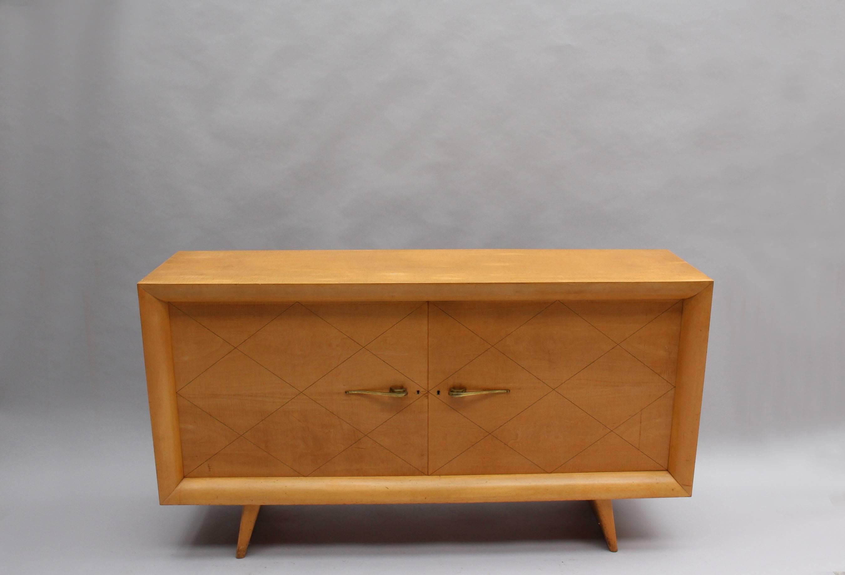 A fine French Art Deco Sycamore buffet with a diamond pattern and brass pulls on the two doors.
Two buffets are available.