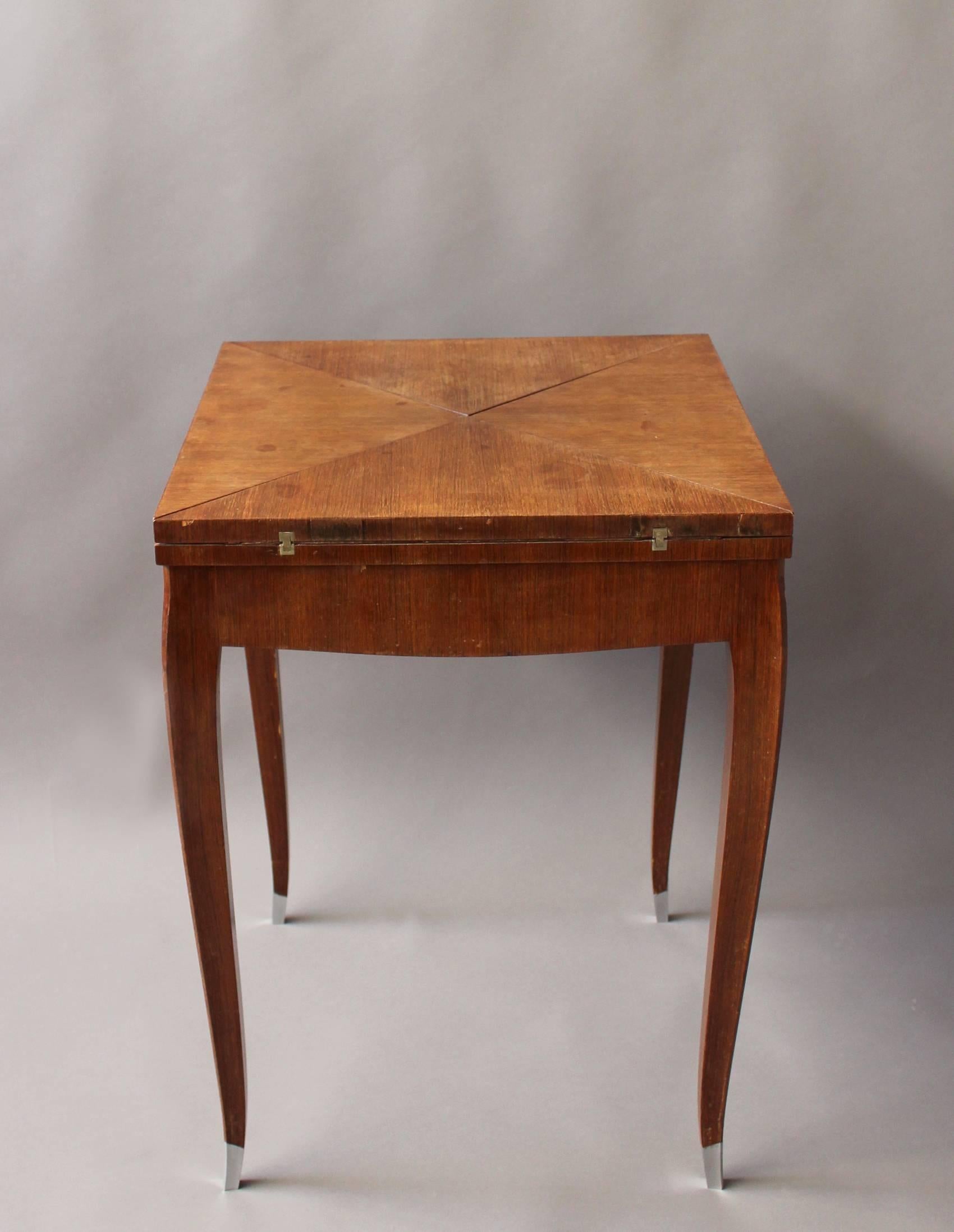 Fine French Art Deco rosewood envelope game/side table.
The top opened as an envelope to be used as a game table.
Four curved legs with silver plated sabots.
Very elegant.
Dimensions of the table opened is H 29.33  x  W 31  x  D 31 in.