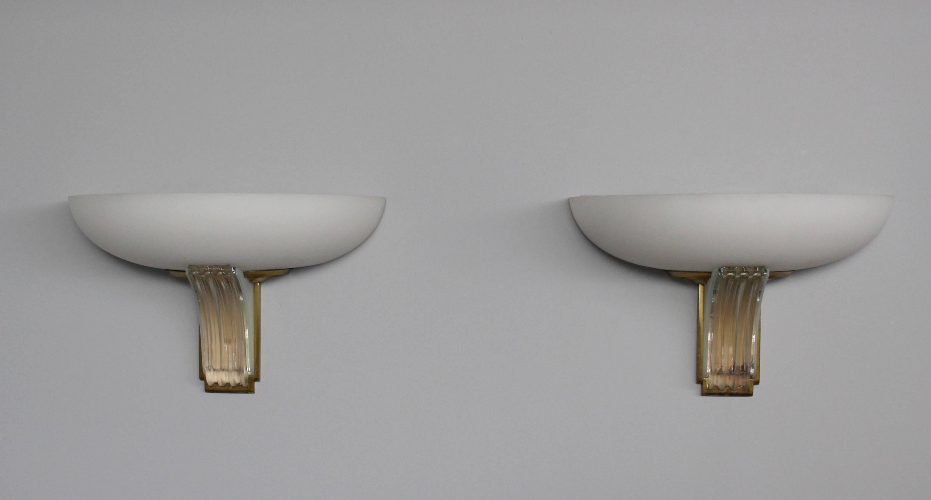 A pair of fine French Art Deco clear and frosted glass sconces by Jean Perzel with bronze details.Shade is made with white opaline. Signed.