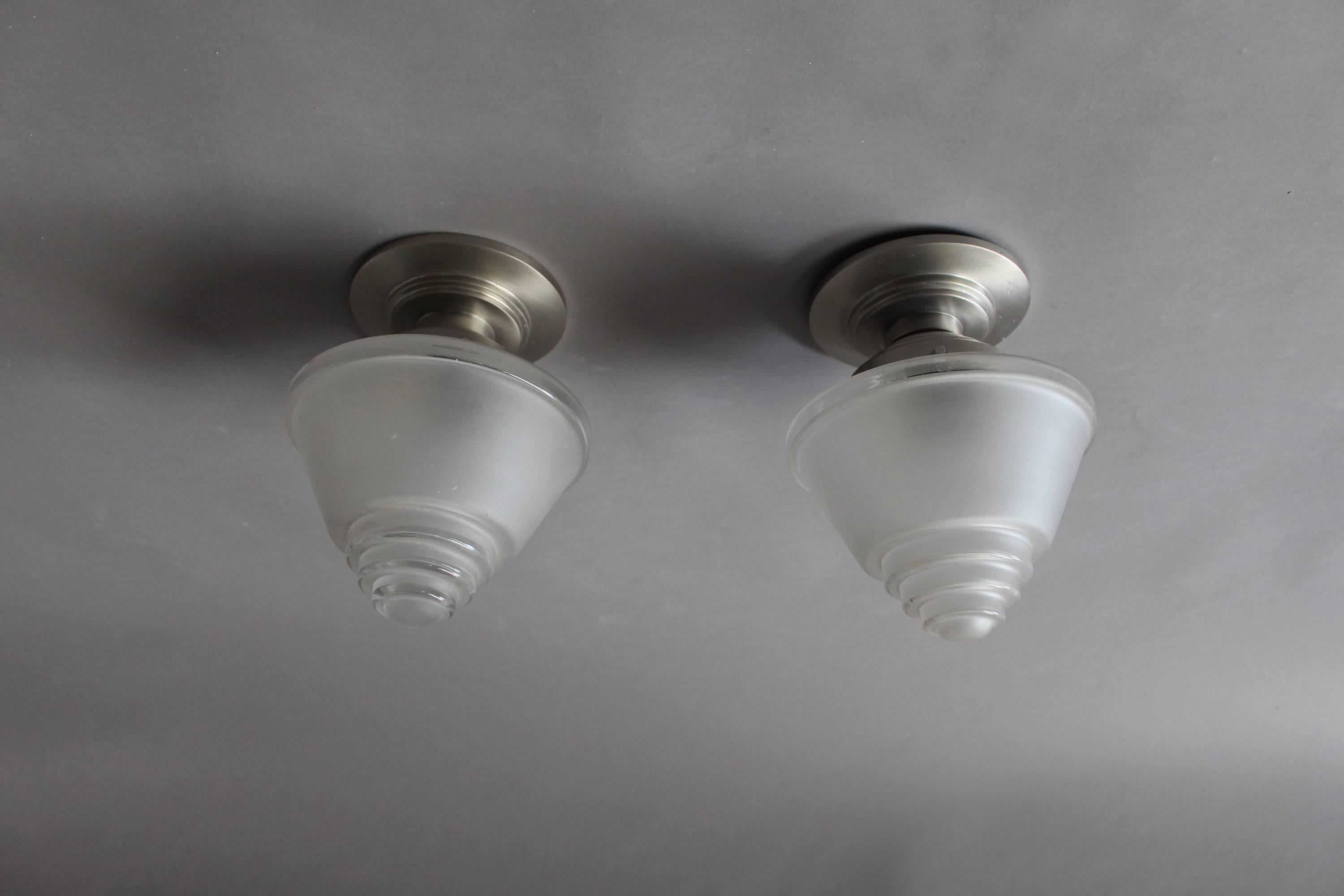 Two fine French Art Deco flush mount fixtures with chrome base and a frosted glass conical shade.