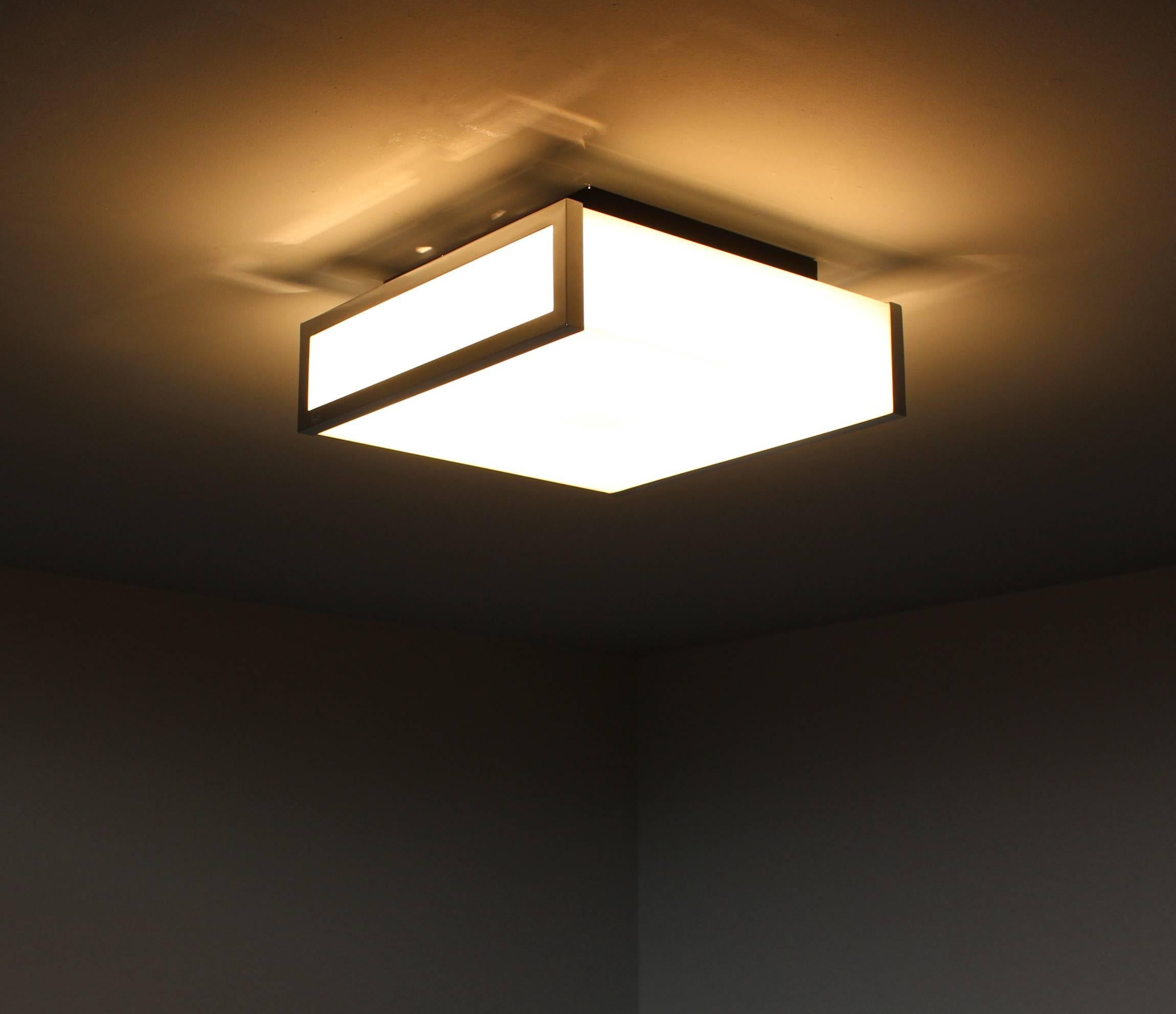 With a minimalist chromed frame that holds the white enameled glass shades which diffuse a nice bright light.
Can be used as a ceiling or wall light.