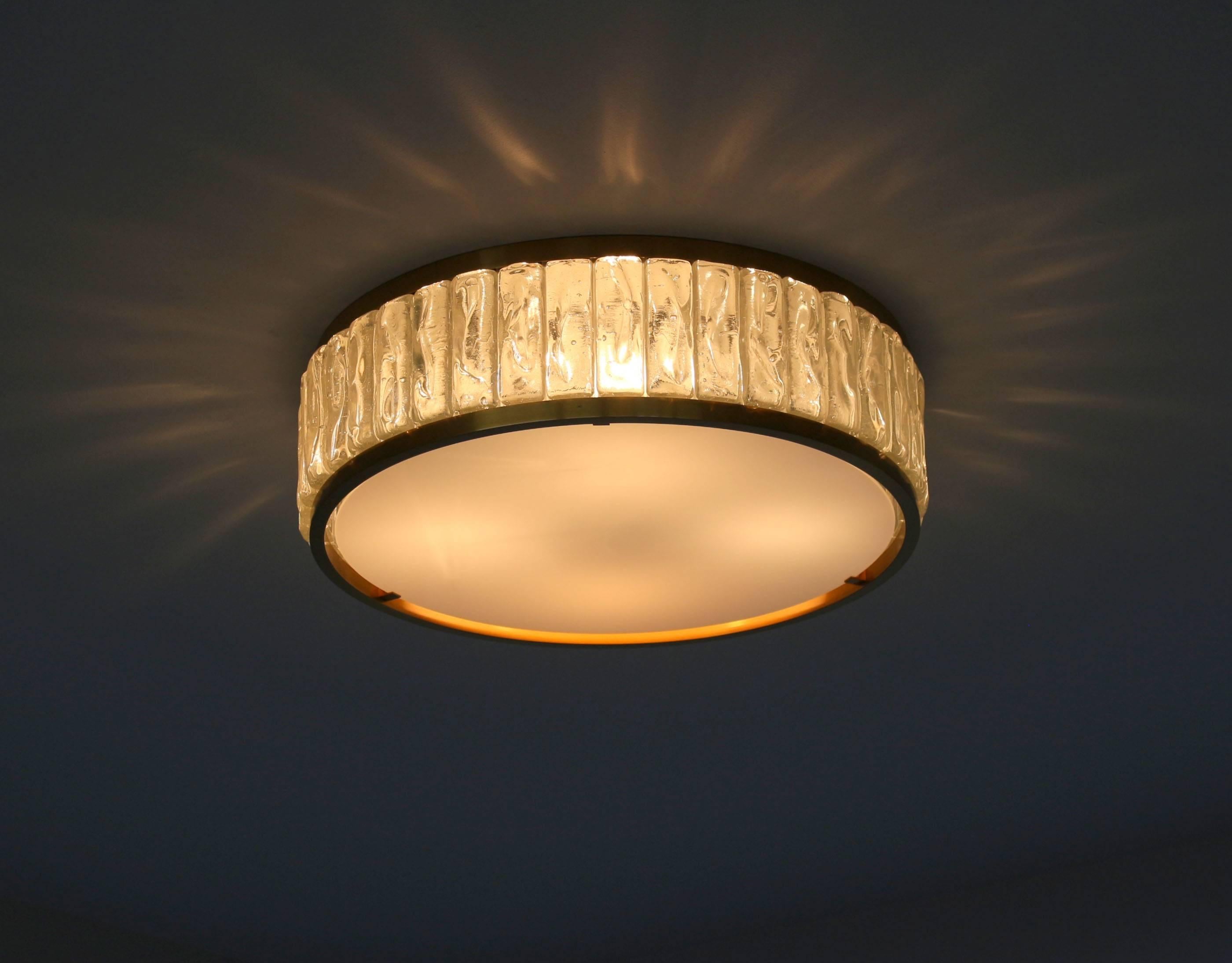 French Art Deco flush mount or ceiling light by Jean Perzel made with some rough laid glass slabs set between two brass frames that support a white opaline glass shade.
Model # 2058 A.