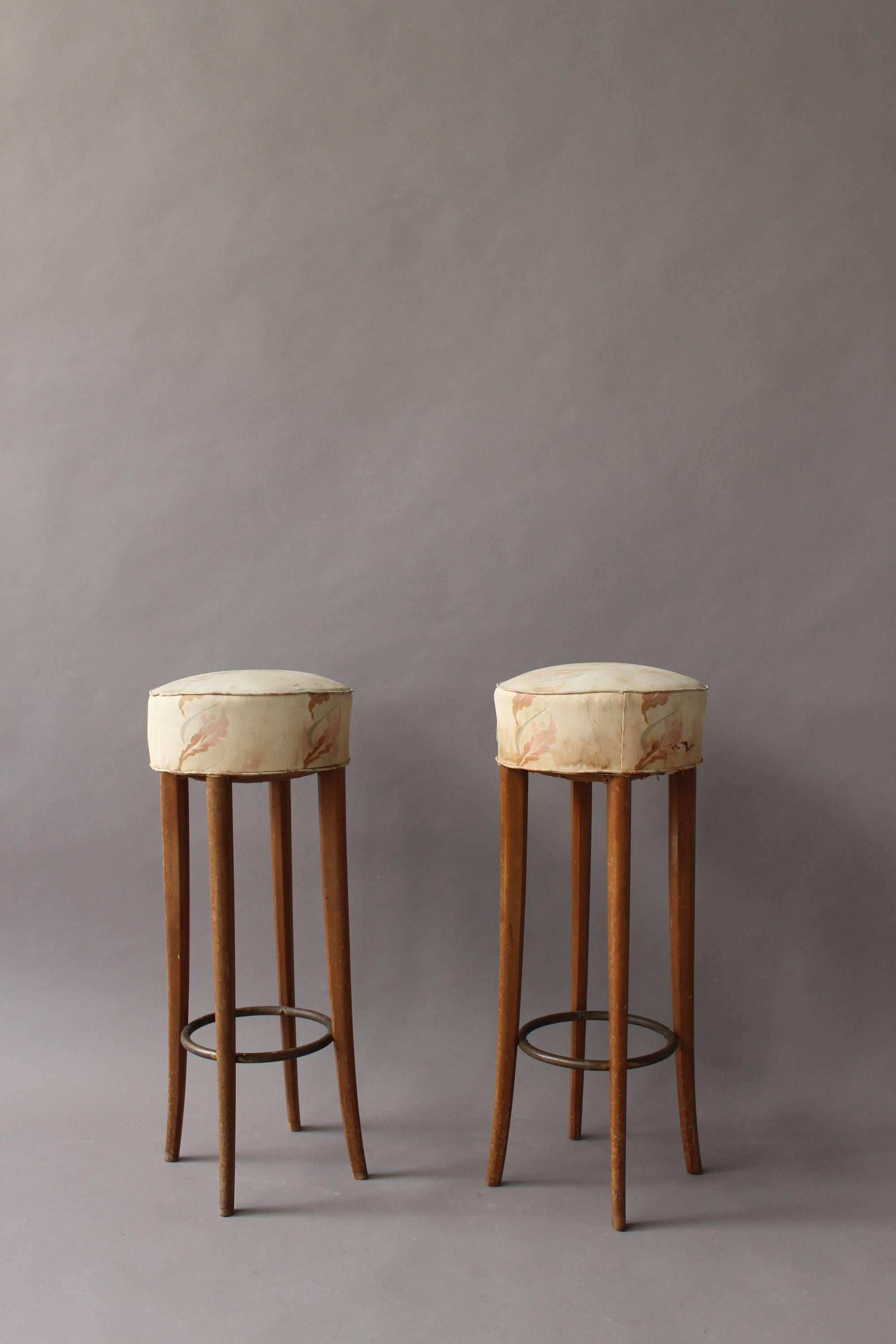 A pair of fine French Art Deco bar stools with patina-ed brass footrest.