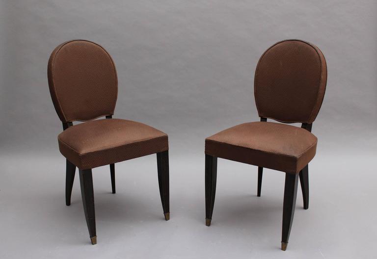 A set of six fine French Art Deco ebonized beechwood dining chairs with oval backs and brass sabots.
   