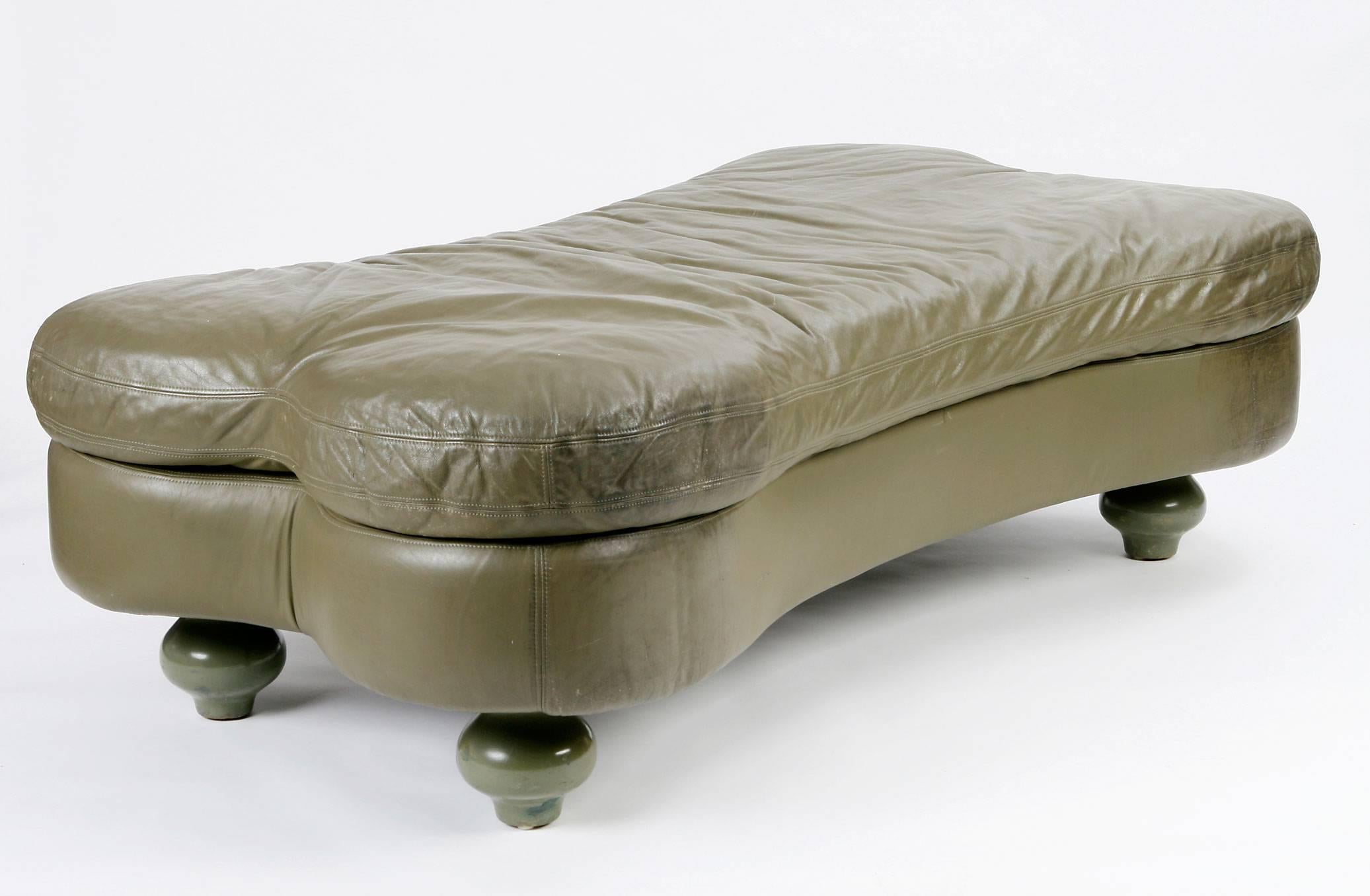 Bone-shaped daybed in olive leather raised on four lacquered turnip feet.