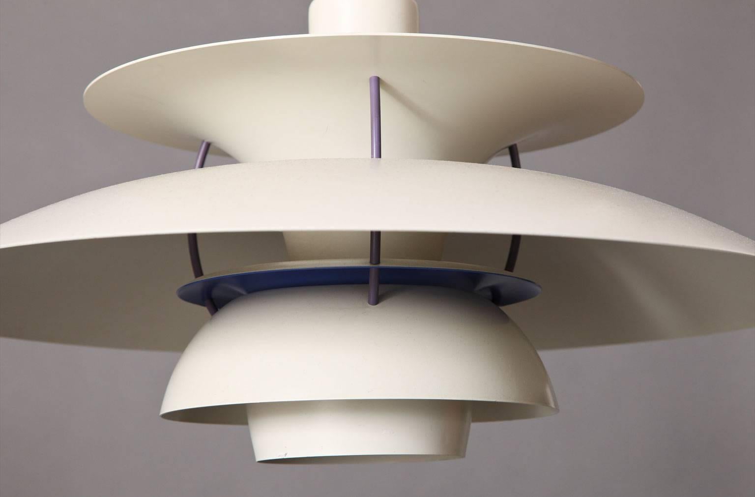 Poul Henningsen (1894-1967).
Pair of enameled aluminium hanging lights with off-white enameled finish and interior reflector shade in violet. Suspended from cloth wrapped cord and attached with red interior and vent disk,
Danish, circa