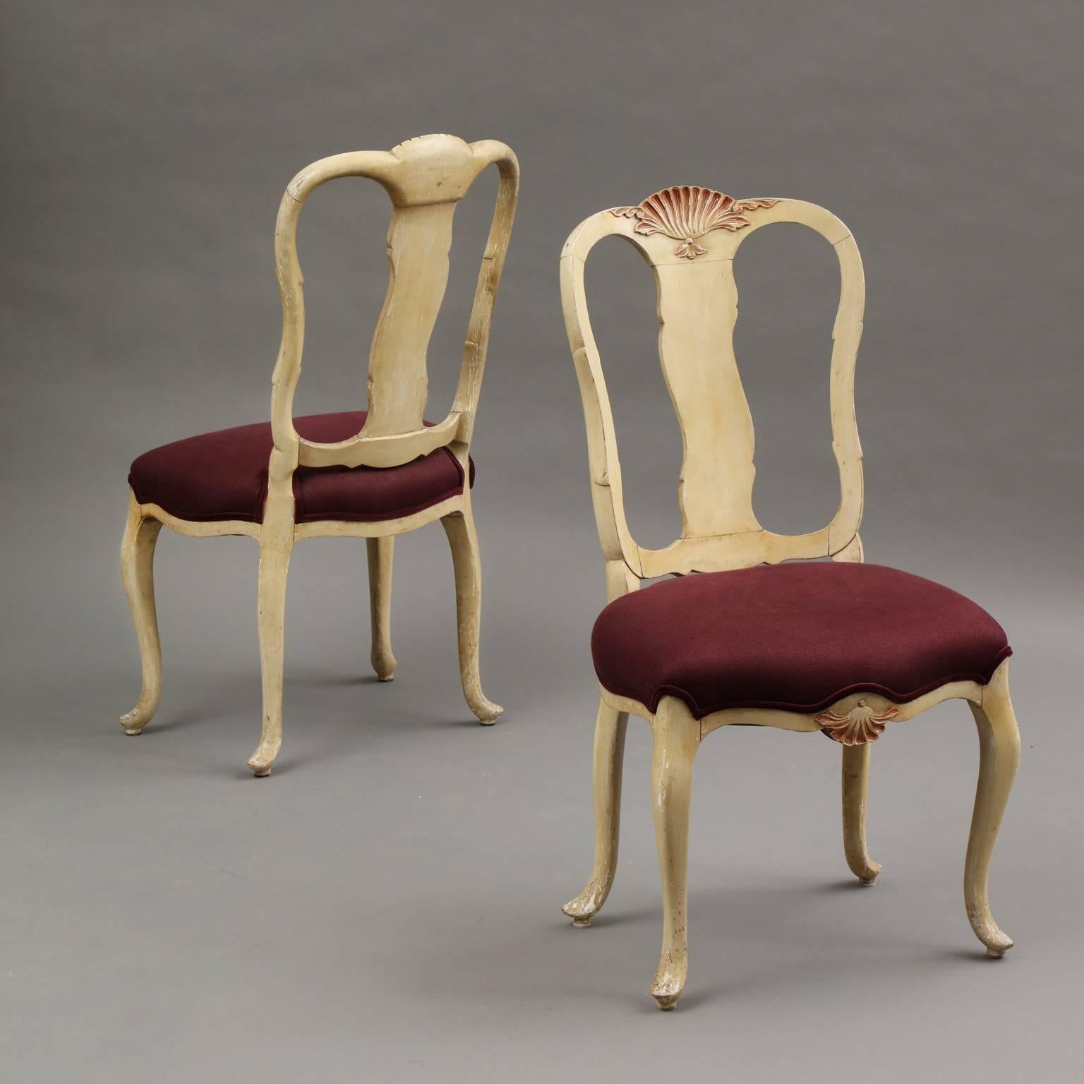 Syrie Maugham (1879-1955)
Pair of splat-back Queen Anne style side chairs in ivory painted wood with pale pink carved shell and scroll decoration. Raised on cabriole legs with pad feet. Upholstered in burgundy linen with velvet welt trim.
English,