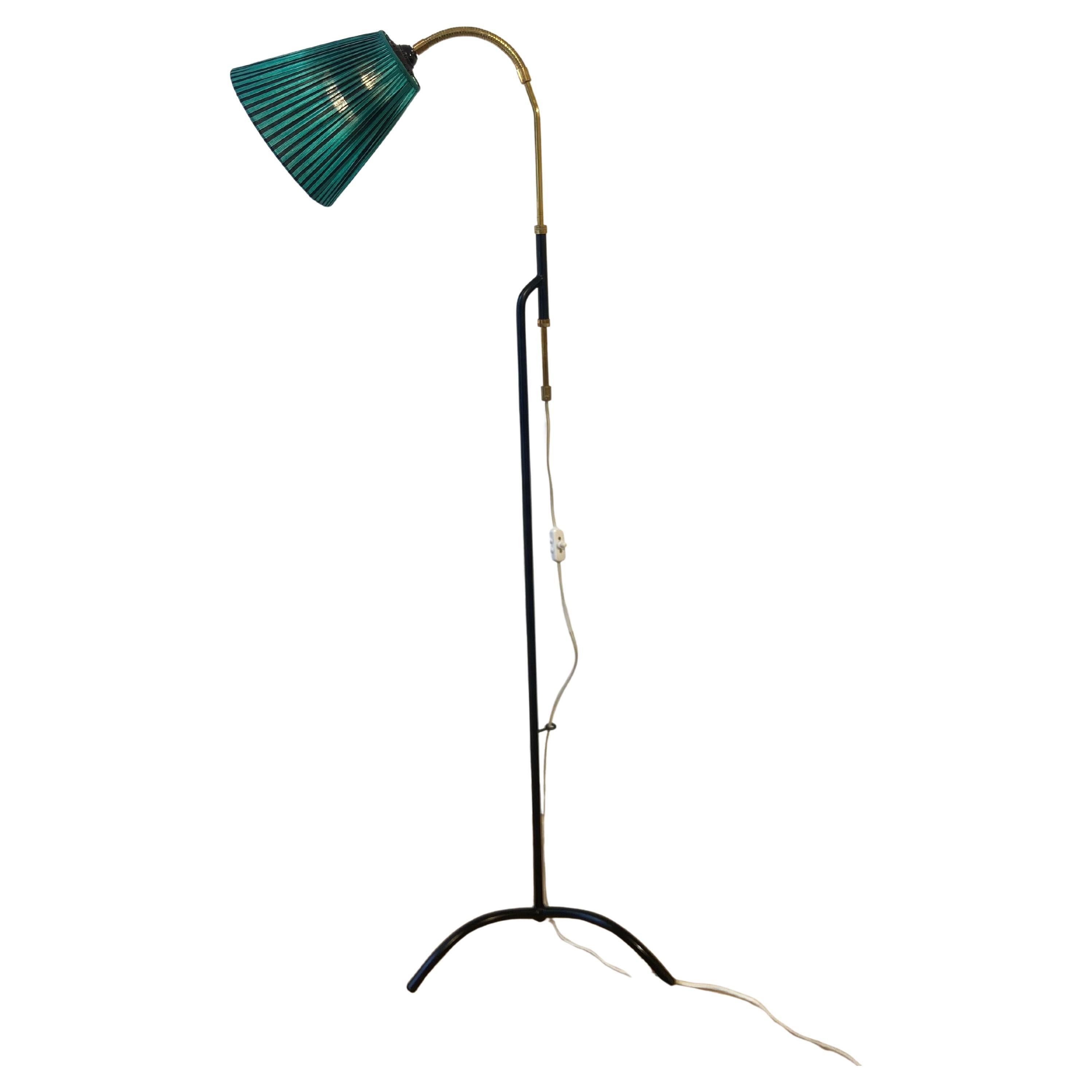 This elegant floor lamp, designed by designer Svend Aage Holm-Sørensen, is a beautiful piece with a refined design. The slim black metal structure contrasts with the brass upper with its height-adjustable and articulated arm. Its tripod base gives