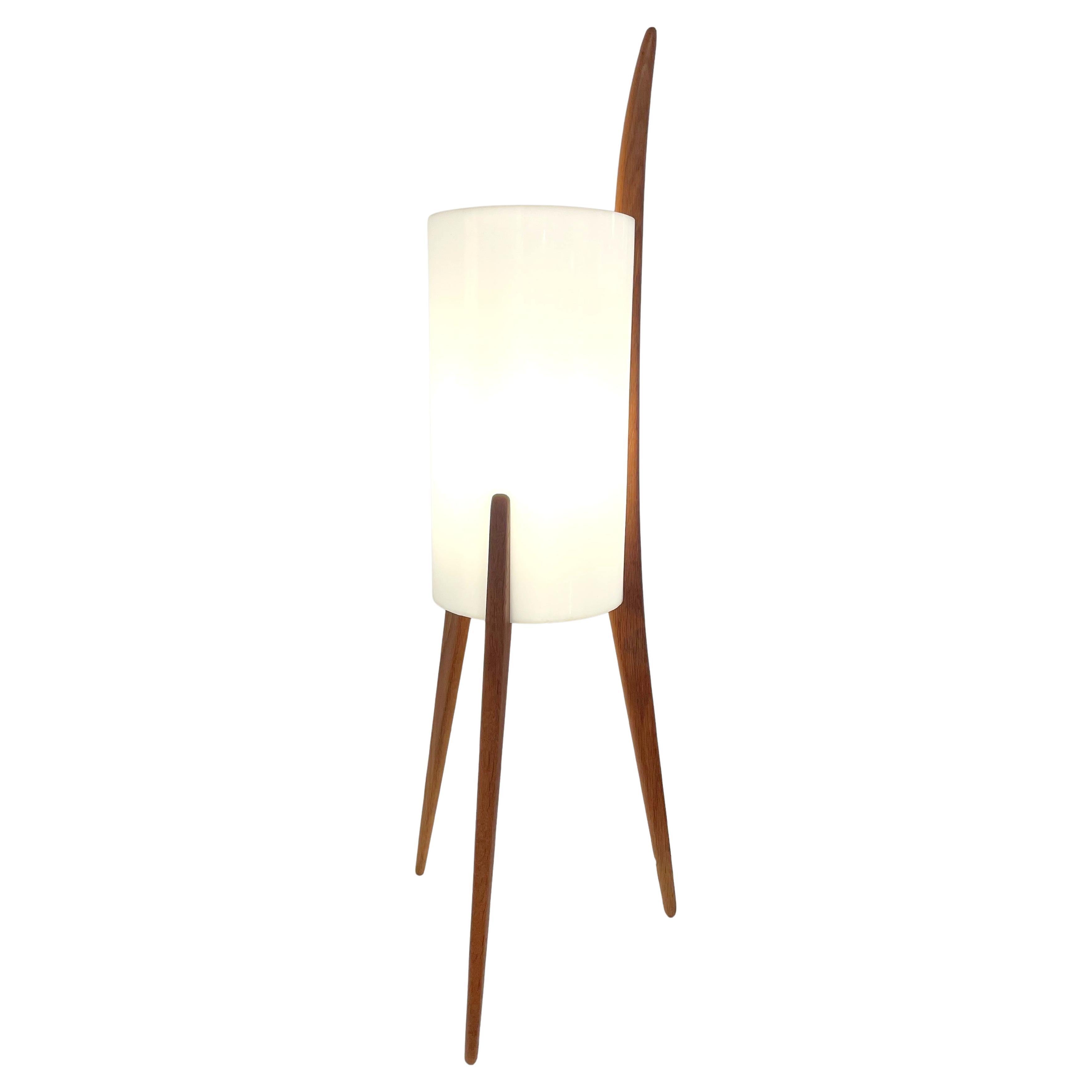 Un design original et élégant des frères Uno & Östen Kristiansson pour leur propre maison d'édition Luxus.
Cette lampe a une structure en tecksupportant un abat-jour en perspex qui offre une lumière douce. Le cordon électrique blanc qui traverse le