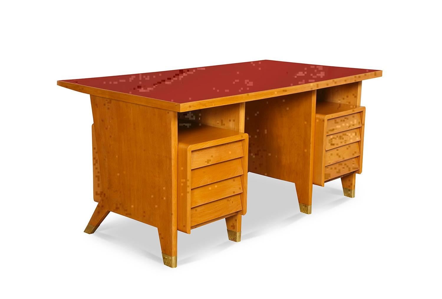  Gio Ponti custom eight-drawer desk.  From a small edition created for administrative offices in Forli, Italy. Blonde wood desk with red linoleum top, shingled drawer faces and brass cuffs at feet. A great, graphic form that rarely turns up.