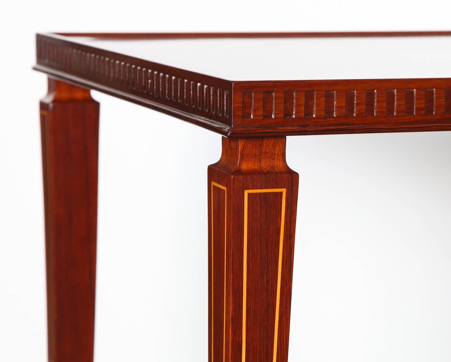 Elegant pair of side tables by Paolo Buffa.  Great pair of rosewood tables, with shaped and tapered legs. Carved details around the outside edge of the top and inlaid light wood along the face of the legs. Beautiful brass cuffs and feet. This pair