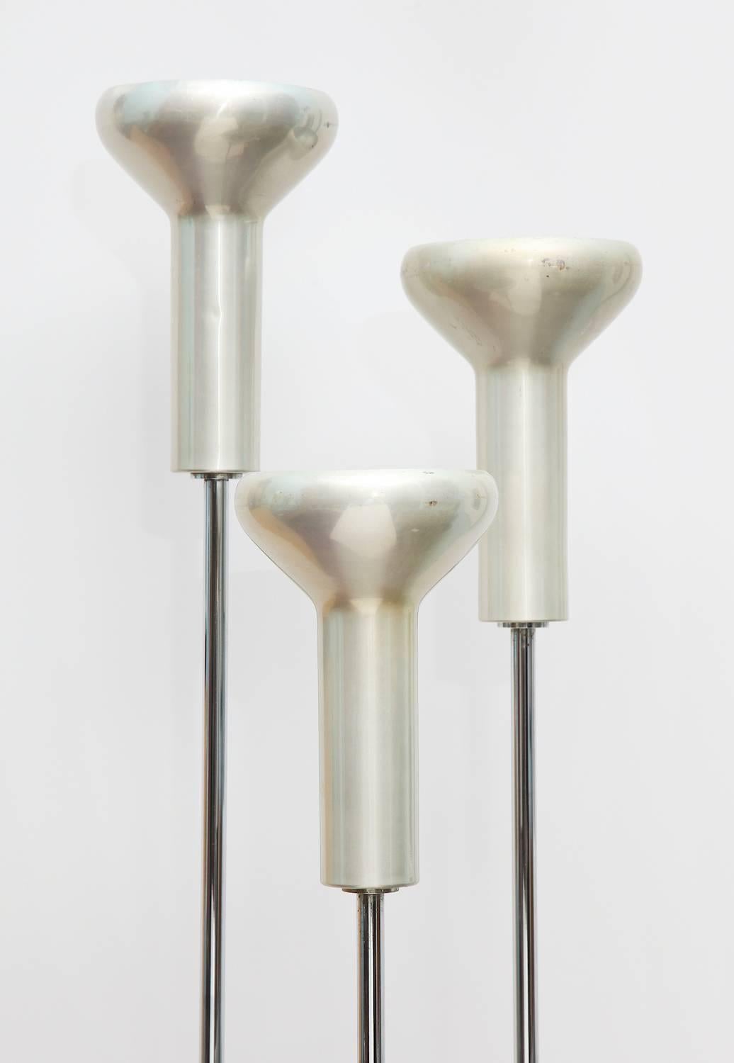Set of three floor lamps, by Gino Sarfatti for Arteluce.  Model # 1073, architectural cluster floor lamps. Black, enameled steel bases with chrome plated steel and aluminum heads. Bases are designed to fit inside of each other creating a