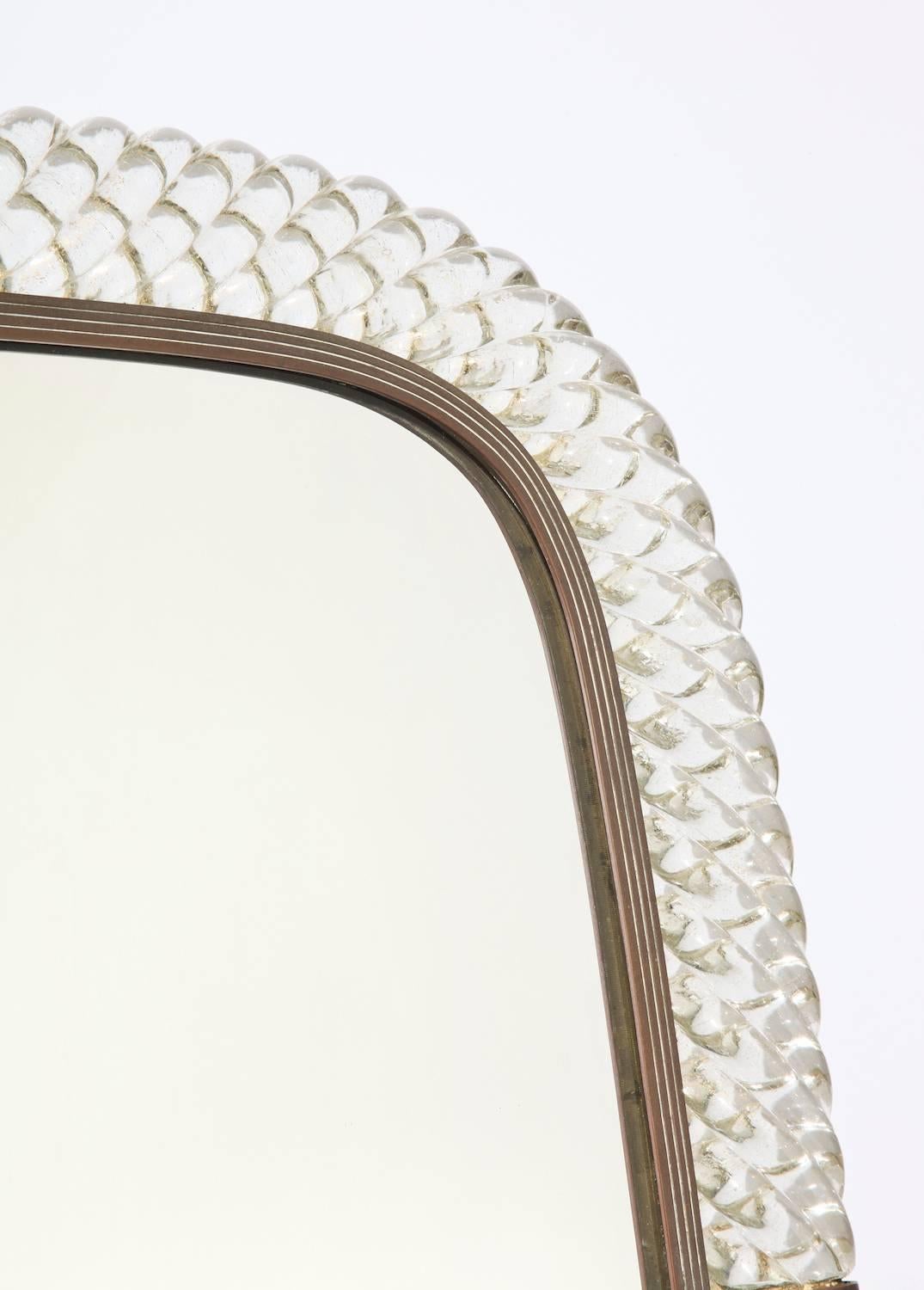 Rare large scale tabletop mirror by Venini. Braided, clear glass frame with gold inclusions, brass interior trim and two brass bands on each side. Plywood back and brass mount with adjustable stand. Manufacturer’s stamp into the brass. Model #42-9.