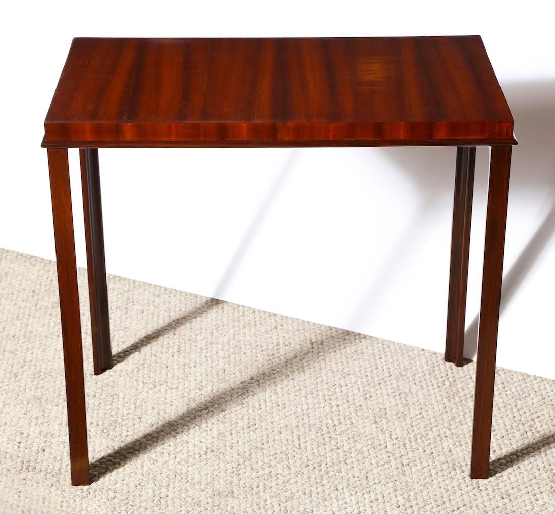 Unique console table by Eugene Schoen.  Small scaled console table designed by Schoen and built by Schmieg & Kotzian.  Top of highly figured ribbon mahogany inlaid with stipes of ebony. Legs of solid teakwood and branded with designer and makers