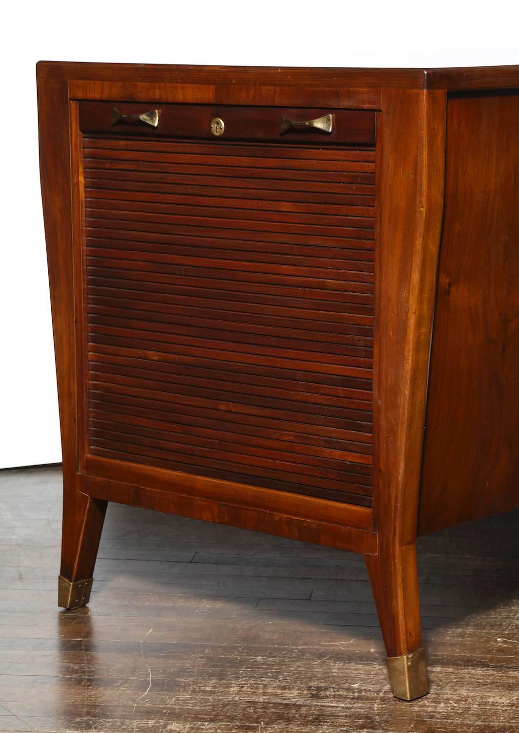 Gio Ponti elegant writing table/ desk. Rare walnut desk with single center drawer. Side storage shelves concealed by tambour panels. Brass handles and sabots. Produced by Schirolli of Montova, Italy. This desk has been authenticated and registered