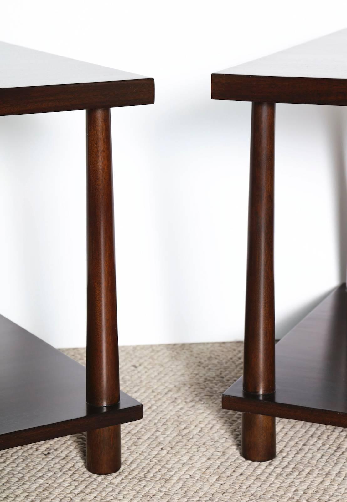 Elegant pair of walnut tables with square tops and lower surface. The reverse-tapered dowel legs create a nice contrast to the sharp lines and angles of the vertical surfaces. Signed on underside with manufacturer's label.