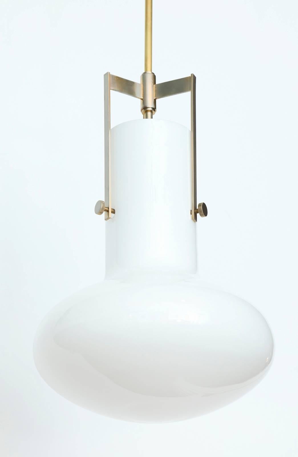 Elegant pendant light by Venini.
Produced by Venini in Murano. Mushroom-shaped, white glass shade and brass stem and mount. This light has one Edison sized socket and has been rewired for use in the USA.