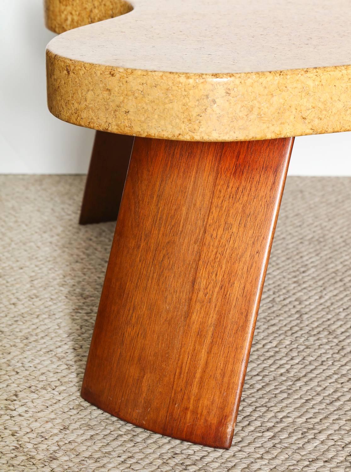 Amorphic Cocktail Table by Paul Frankl. Great form with a cork-wrapped amorphic top and four fin-shaped mahogany legs. The top has a natural cork finish with a few discolorations. Produced by Johnson Furniture Company.