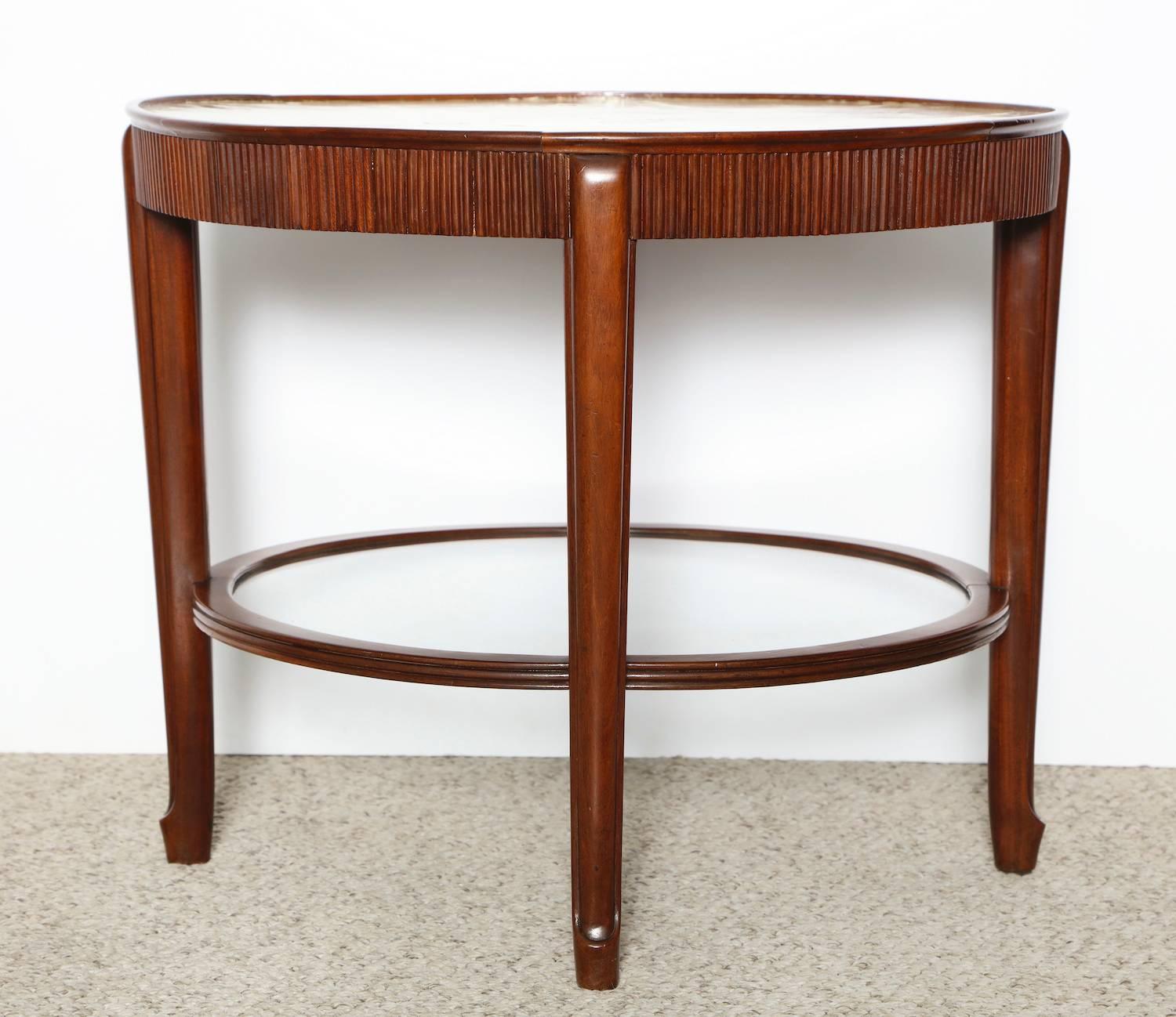 Giuseppe Anzani circular low table with skillfully patch-worked parchment top, and inlaid leaves in wood veneer. Walnut structure with channeled side edge, cabriole legs and glass lower shelf. A beautiful example of the craftsmanship achieved in the