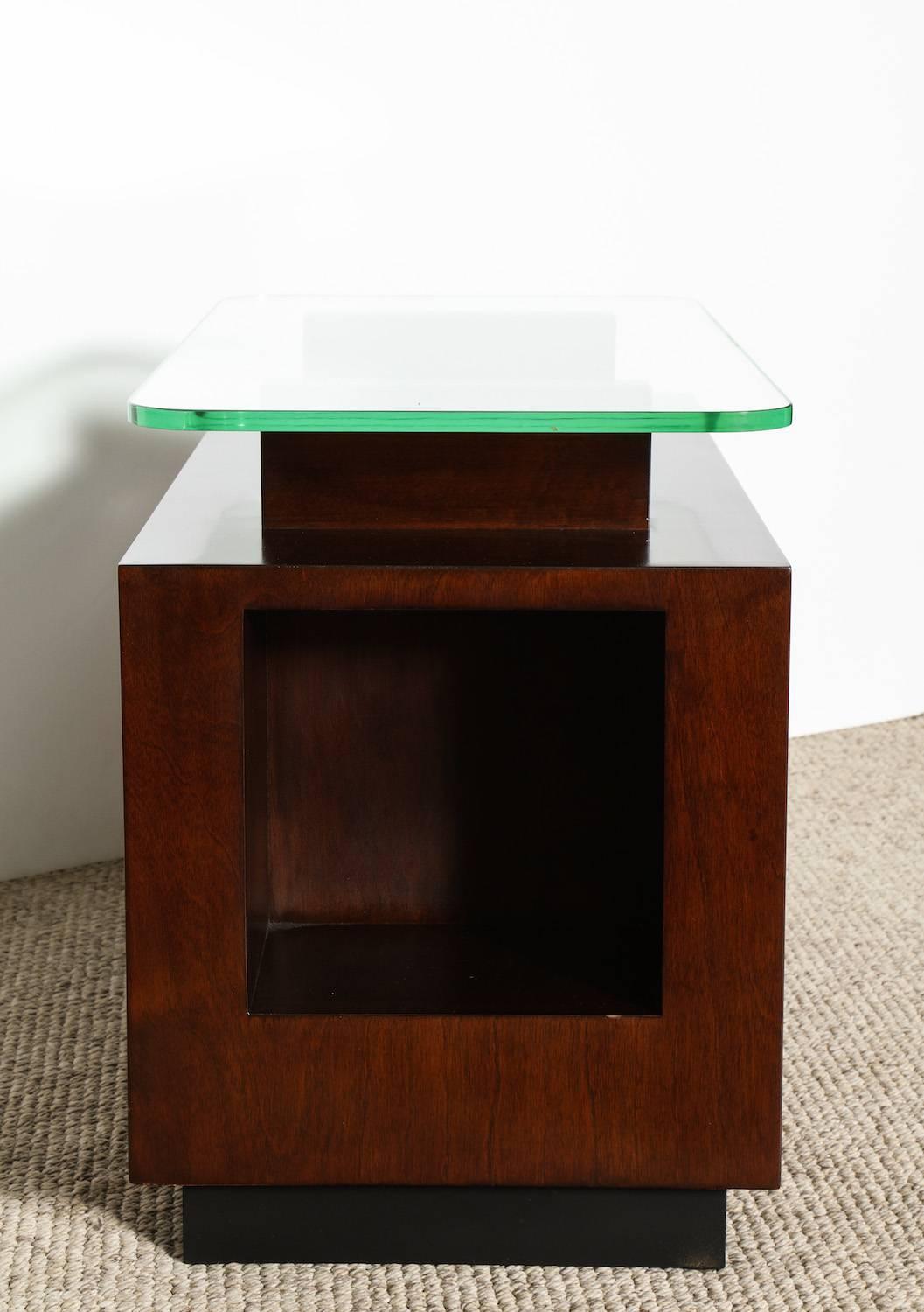 Paul Laszlo, rare custom side table. Paul Laszlo, dark stained wood and architectural form with front cut-out. Two top supports hold a thick floating glass top. From a private residence in Beverly Hills, CA.