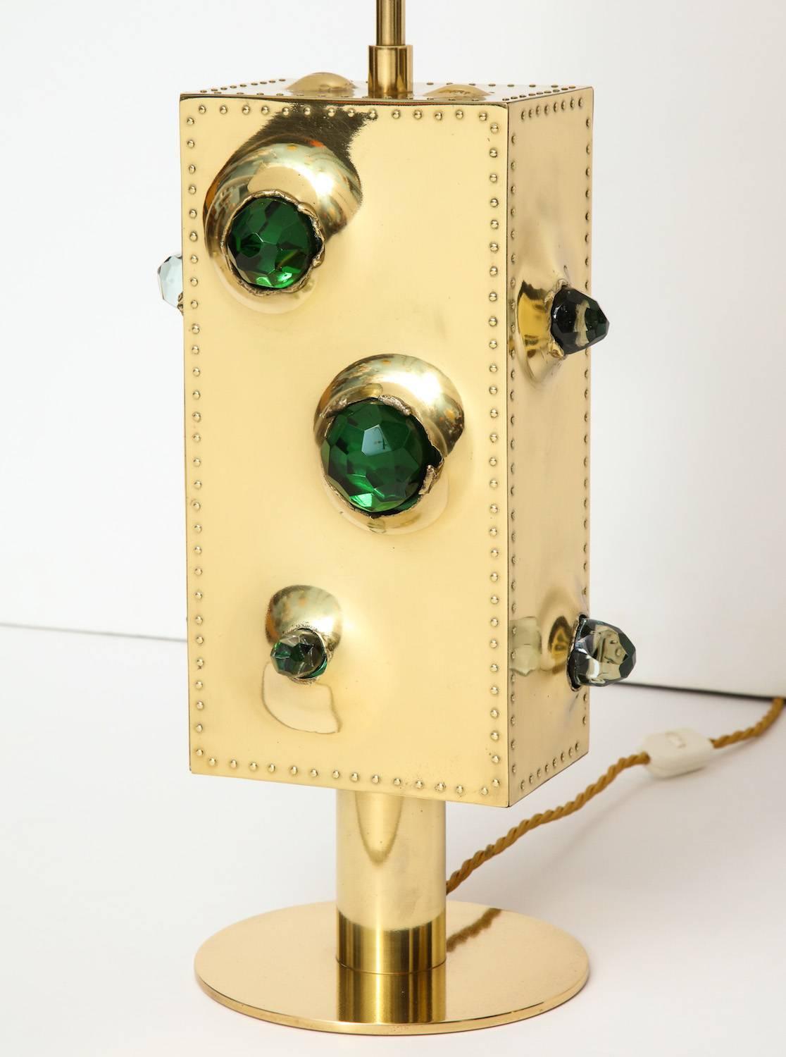 “Luna,” studio-built table lamps by Roberto Giulio Rida. Studio-made lamps of brass with riveted edges and openings to accommodate chunks of emerald green crystal on all sides. Each lamp has two Edison sockets and new silk shades. Artist-signed.