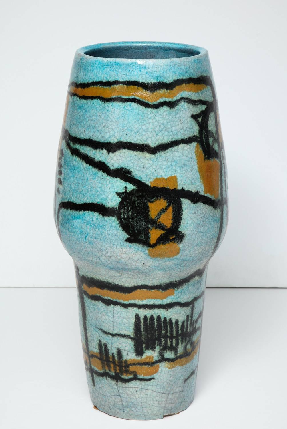 Large-scale, earthenware vase made on a wheel. Exterior has vivid blue glaze with graphic Primitive decoration in black and yellow. Artist signed on underside.