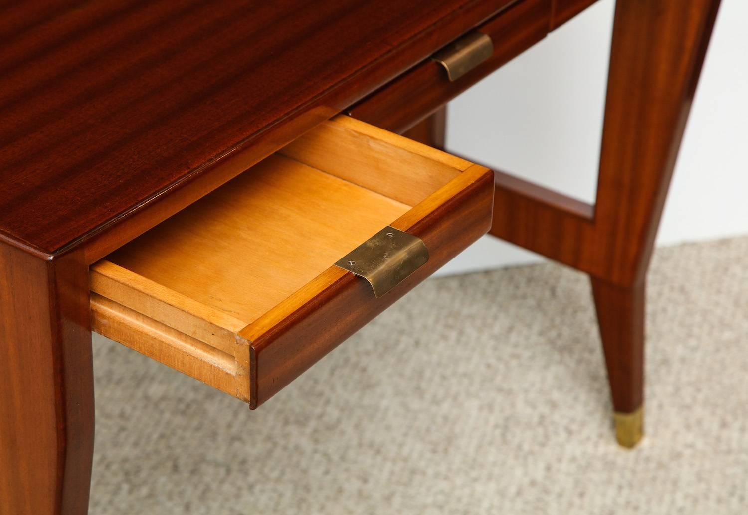 Rare desk / dressing table by Gio Ponti.
Three-drawer desk of ribbon mahogany, with tapered legs, side cut-outs, brass drawer pulls and wraps at the feet. Produced by Giordano Chiesa.