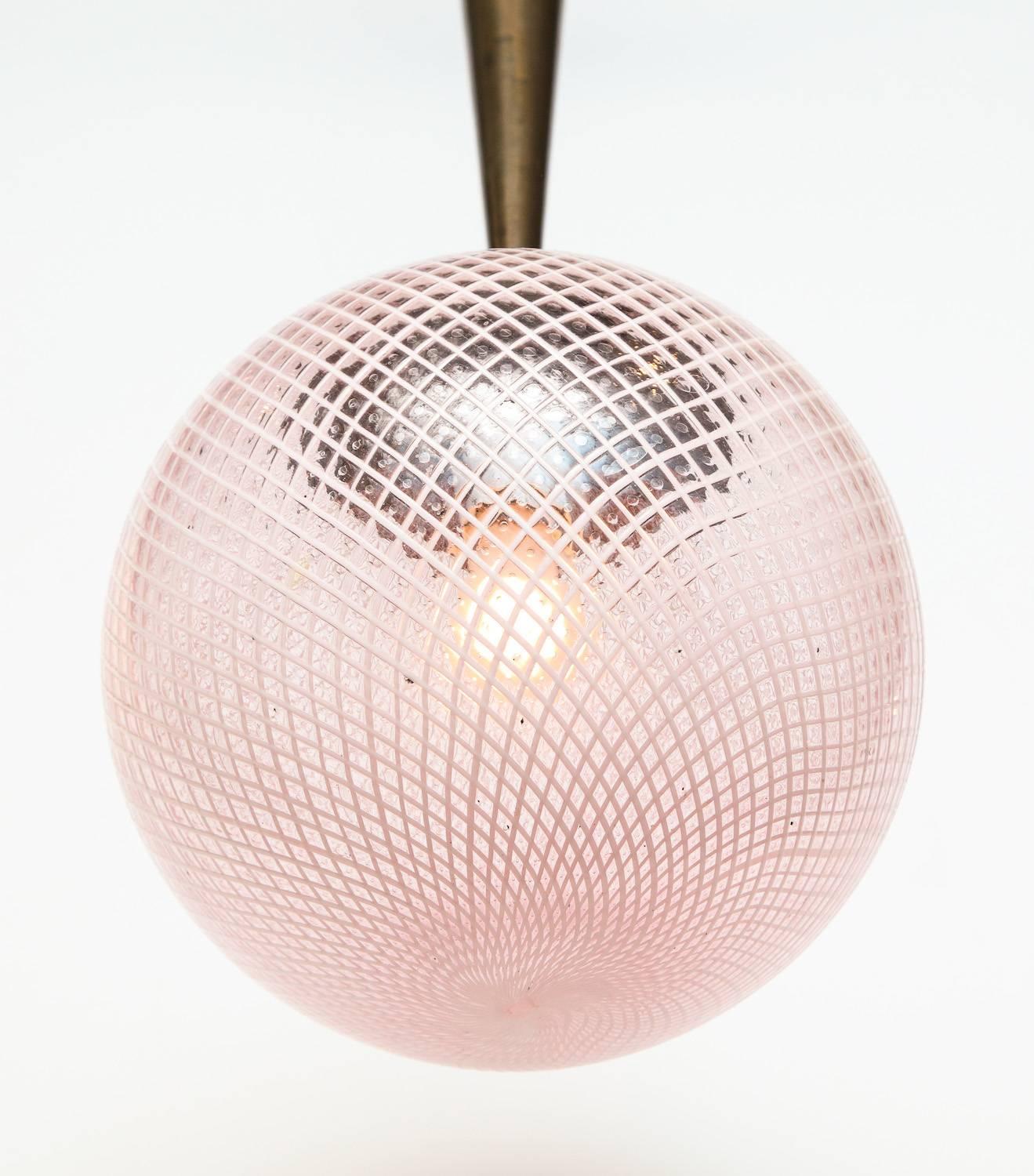 Rare Globe Pendant by Carlo Scarpa for Venini.
Beautiful filigrana glass globe with a pale pink hue. Oxidized brass mounts and cone, and one standard sized socket. The chain was added later and can be removed to decrease the overall drop.