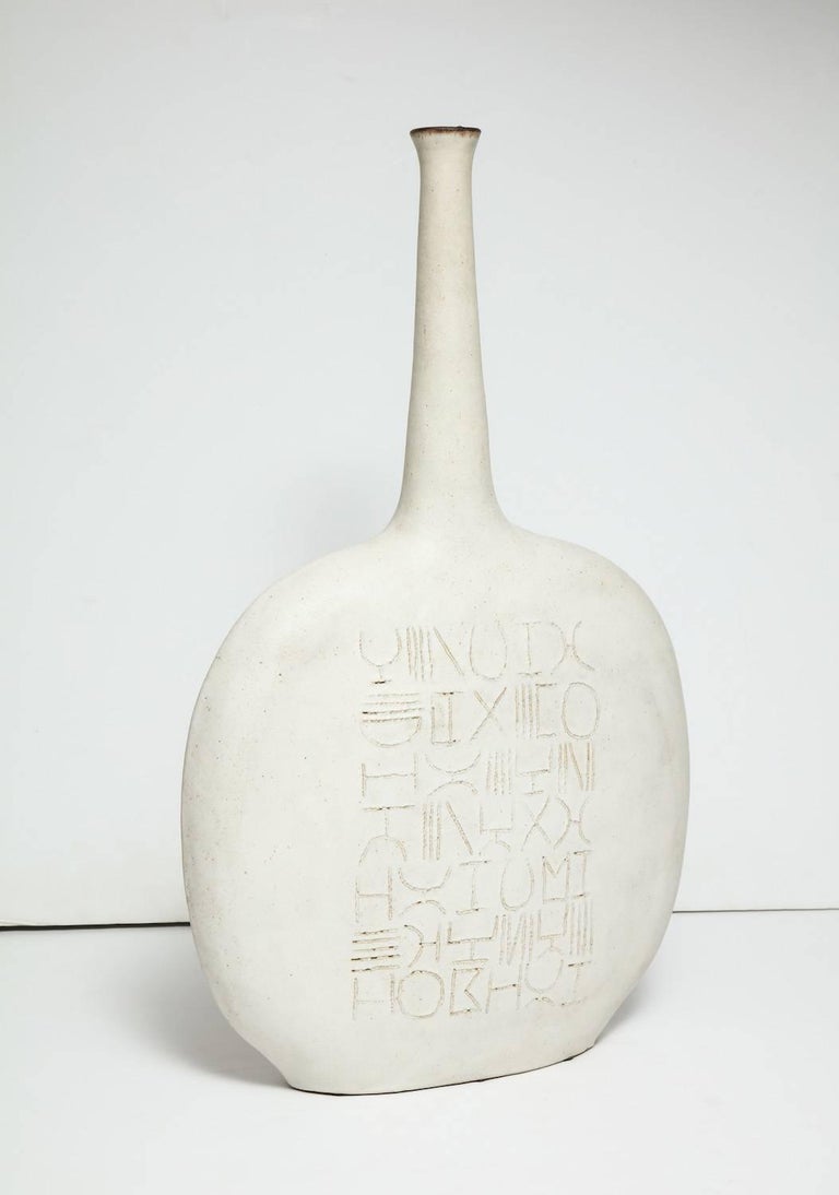Unique bottle-form case by Bruno Gambone.
Large-scale, stoneware bottle-form sculpture/vase with incised line decoration to front and back. Off-white matte glaze with brown lip. Artist-signed at base.