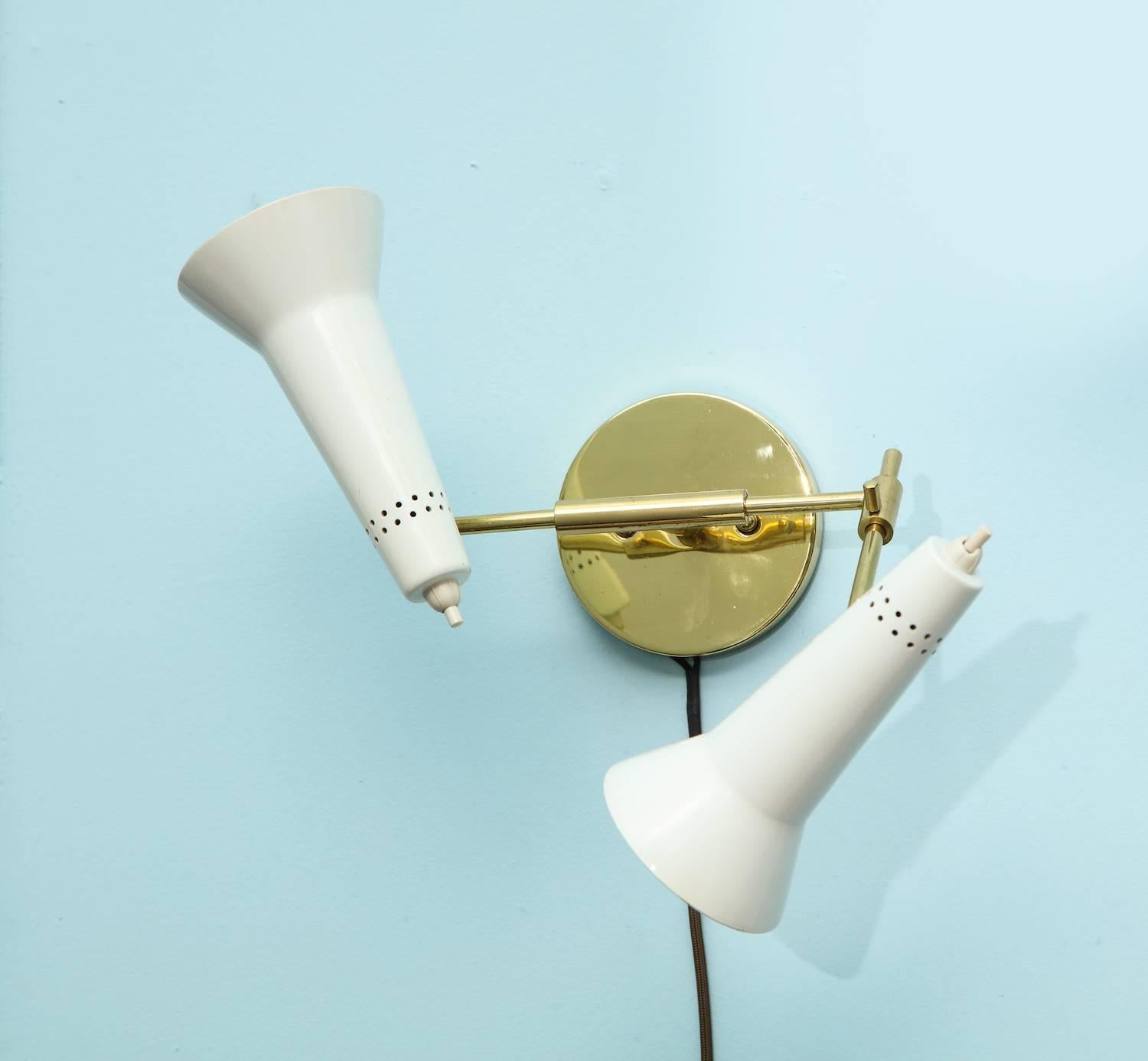 Rare pair of #169/2 sconces by Gino Sarfatti.
Rare pair of two-light sconces with articulating arms and shades. White-painted metal cone shades and adjustable brass arms and mounts. As these sconces move in a number of directions, the measurements