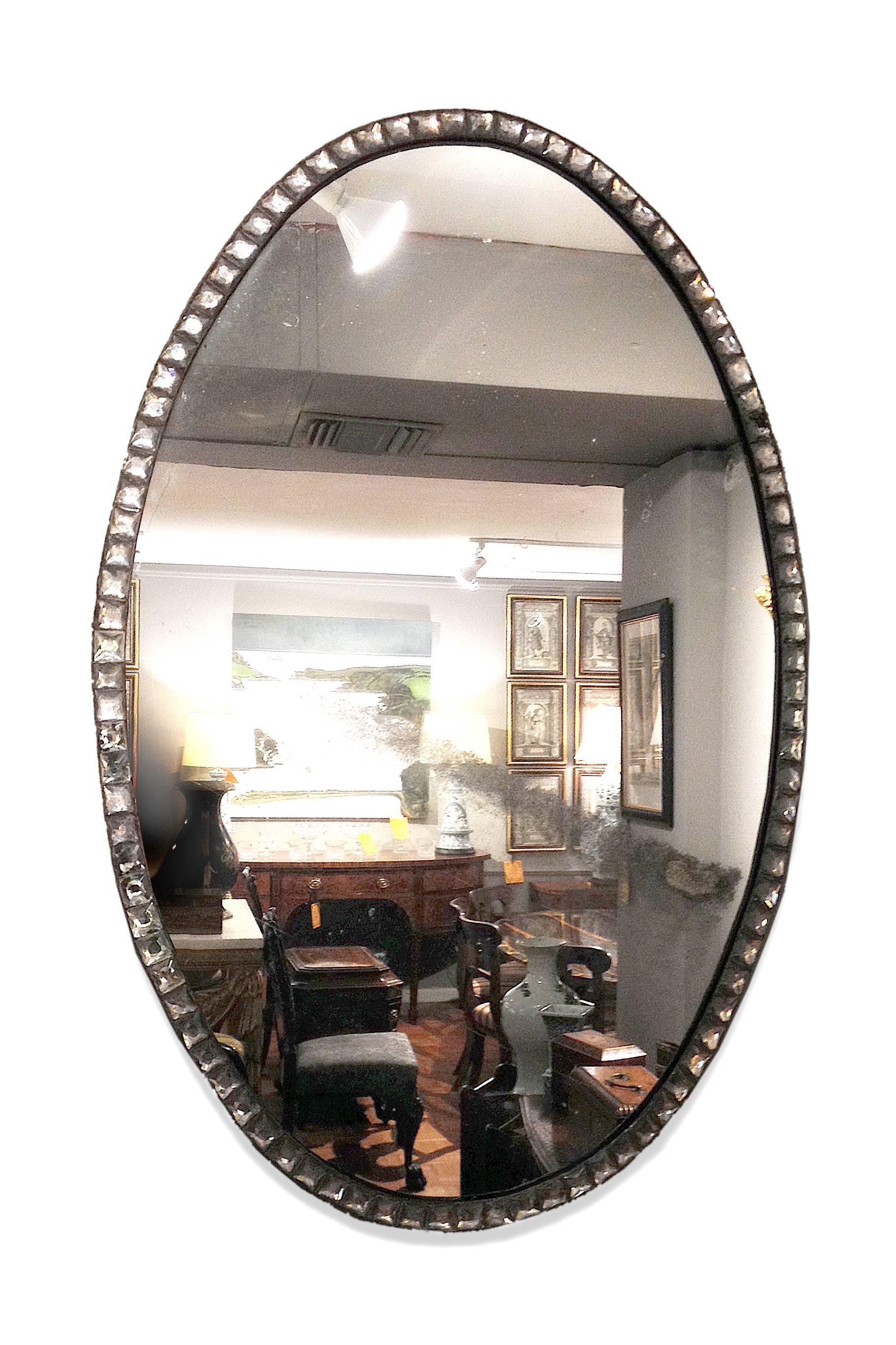 18th century oval clear cut-glass mirror. The faceted clear glass gems set into a metal oval frame.