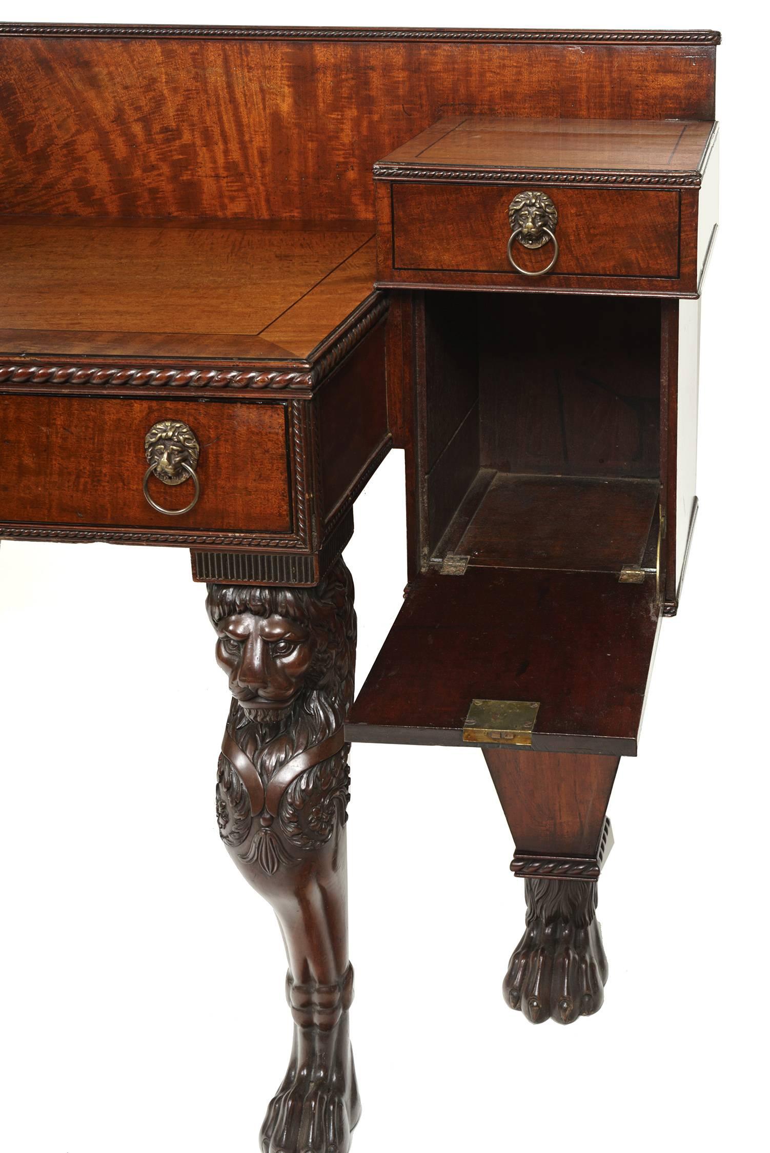 Mack, Williams and Gibton mahogany sideboard with lion monopodium legs. A fine Regency sideboard with a dropped center piece containing two drawers, flanked by downward-opening cabinets, each atop an inverted-pyramid leg and lion's paw foot.