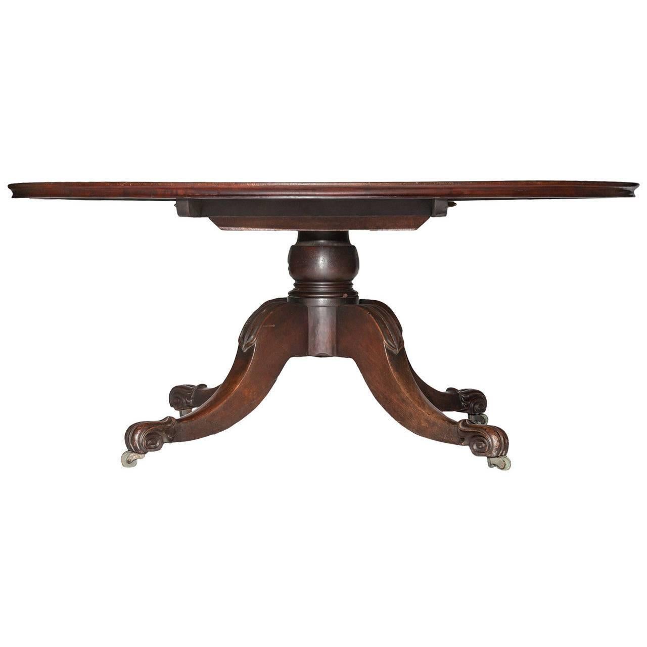 Six Foot Circular Mahogany Dining Table by Mack, Williams, and Gibton. The circular top raised on a large turned and clasped column and four large down-swept and acanthus-carved cabriole legs with brass casters.