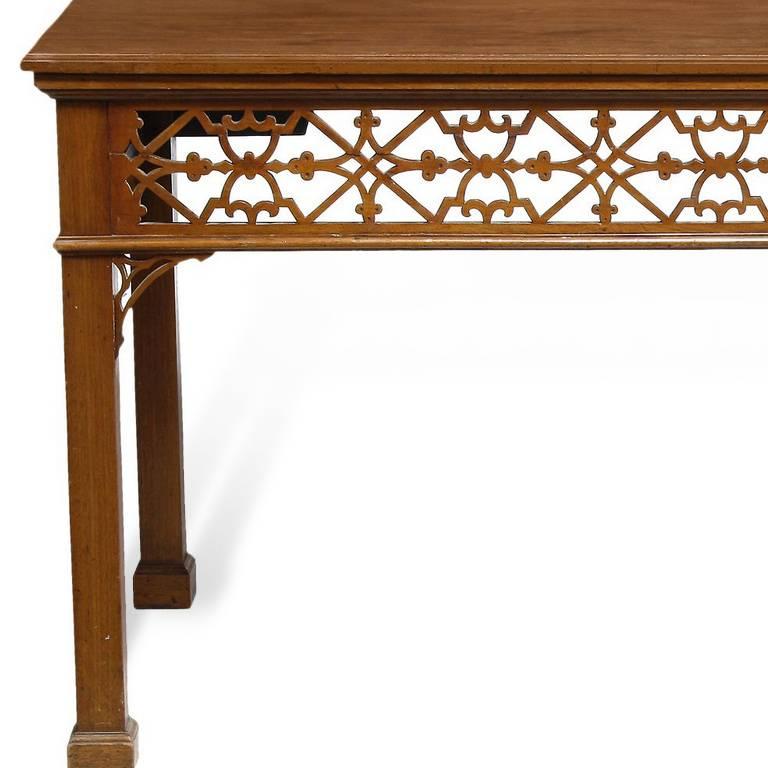 This unusual mid-19th century serving table is distinguished by a Gothic pierced fretwork frieze and similarly pierced corner brackets. The square-section legs end in block feet.
