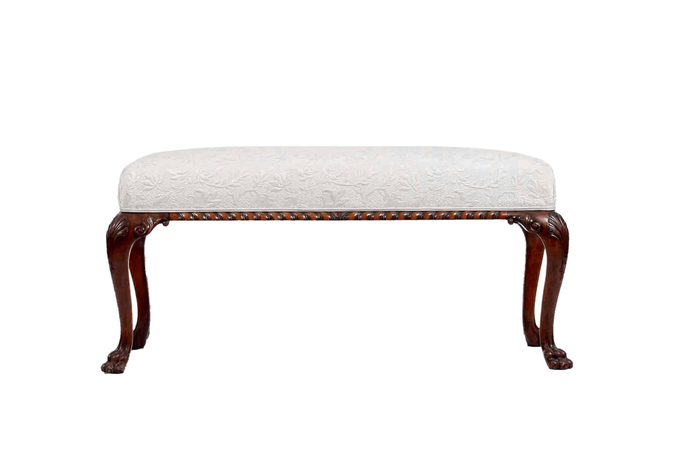 George III carved walnut stool with upholstered seat. With a gadrooned seat rail, shell-carved cabriole legs and paw feet.
