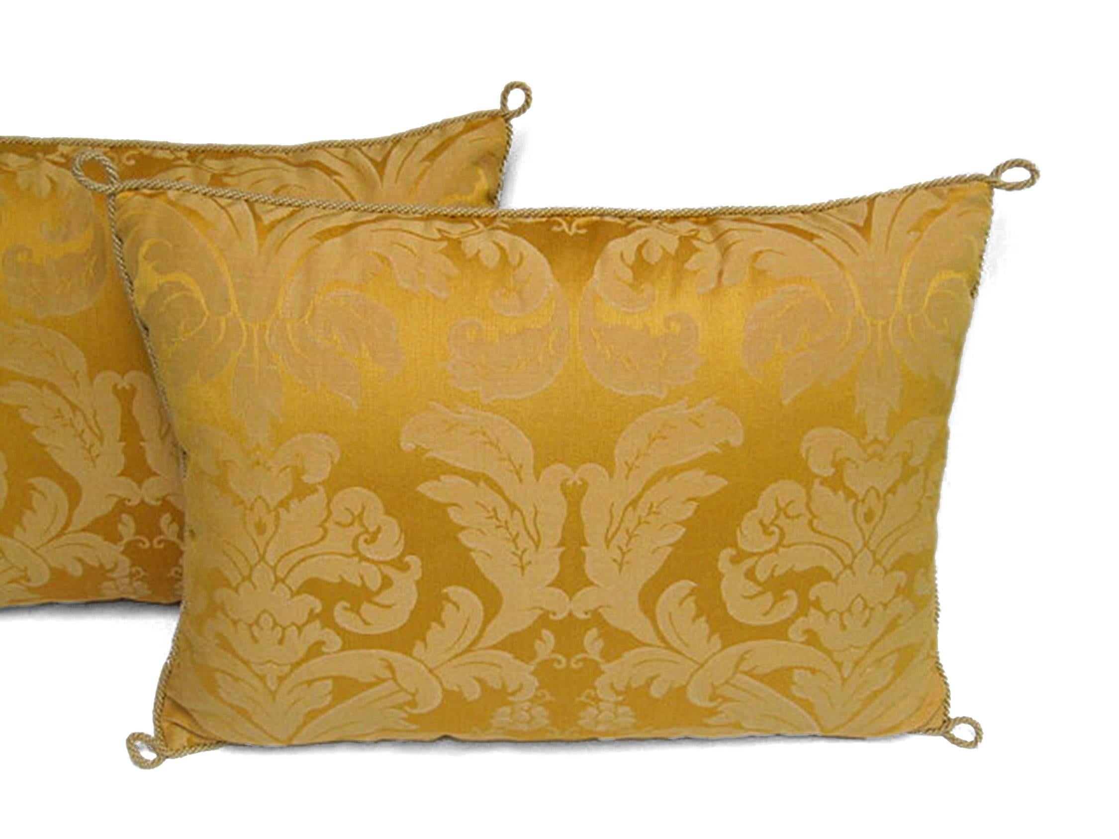 Paire de coussins en damas jaune, faits à la main, avec un motif floral. Garniture en corde avec boucles et garniture en duvet d'oie à 100%.

