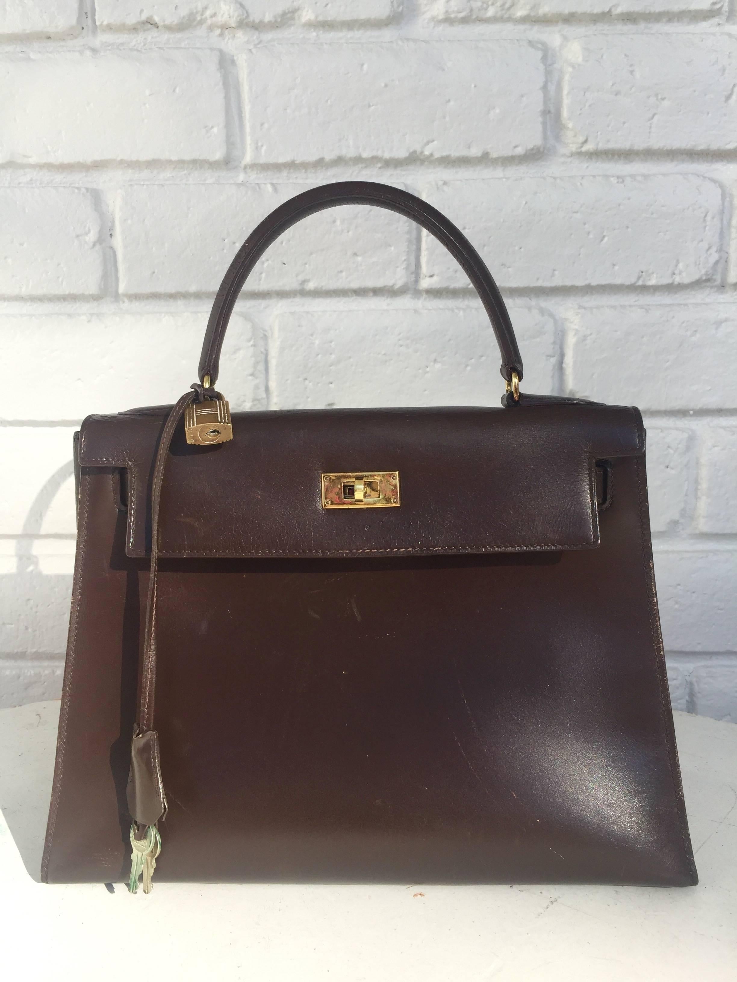 28cm Hermes Paris for Bonwit Teller Kelly Bag.
These bags were tetailed in the mid-late 1960s through seventies long before Hermes had their own boutiques in the USA.
This bag is chocolate brown gold box leather and fitted with bronzed