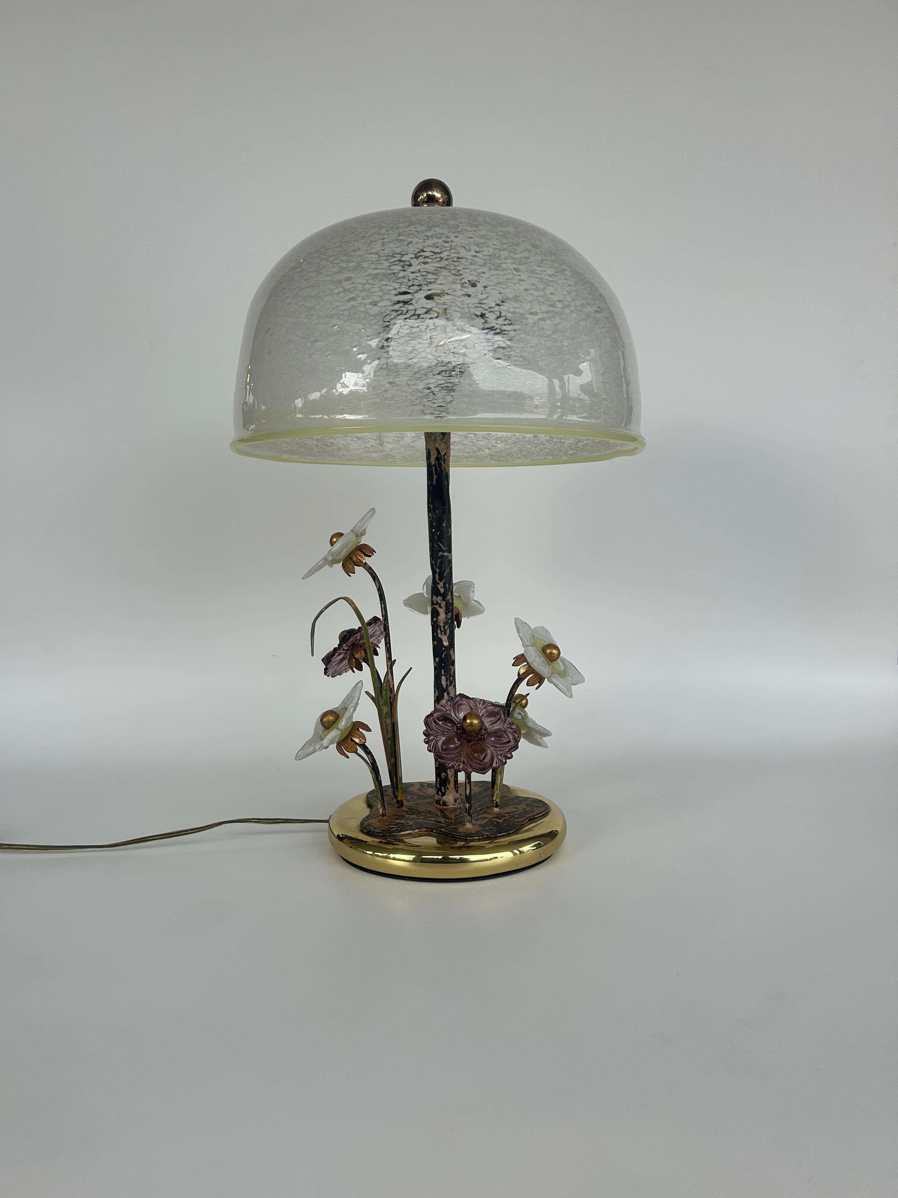 This is an usual find.  
A combination of style and material make this piece unique and a statement.
The glass murano shade and floral decoration give the lamp a warm classic look which is highlighted by the modern brass base.
The scale and