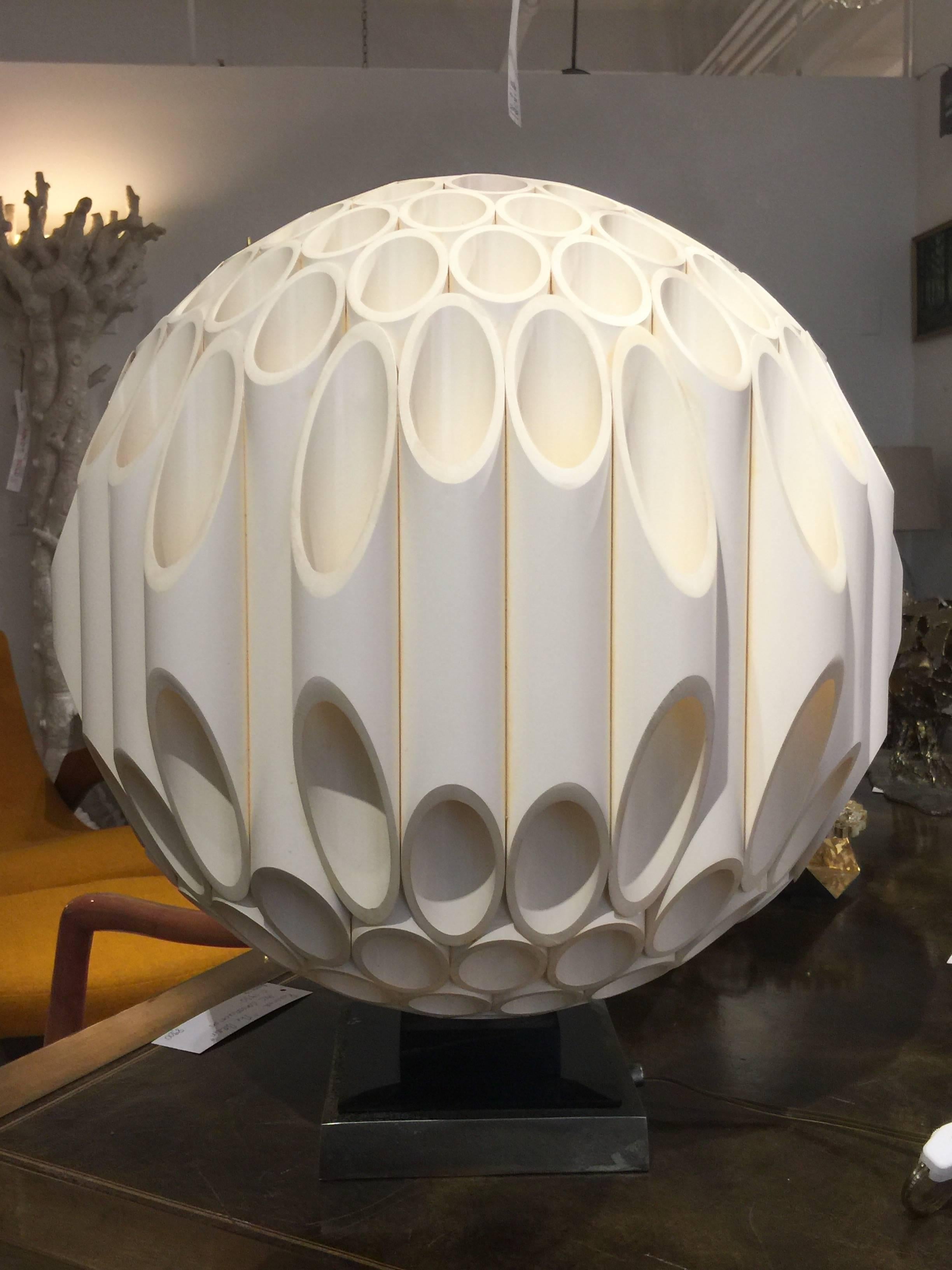 This sculptural and amazing Space Age meets modern lamp is the real deal! It is made up of PVC tubes that is in the form of acrylic. It is signed Rougier with a plate on the black acrylic base in the back. This lamp has been in many movies and TV