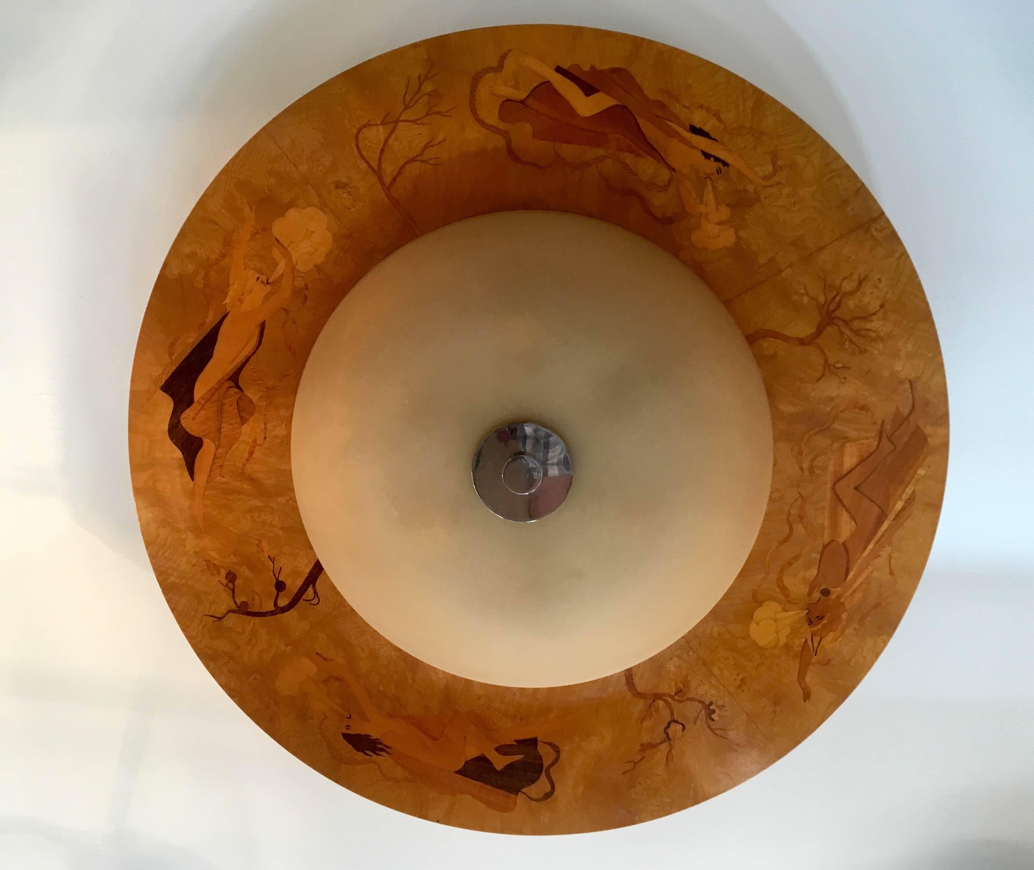 An original hand crafter inlaid Swedish flush ceiling light with a custard glass shade by Birger Ekman for Mjolby Intarsia. Newly rewired. The inlaid decorations are of Nordic gods blowing wind to the trees.