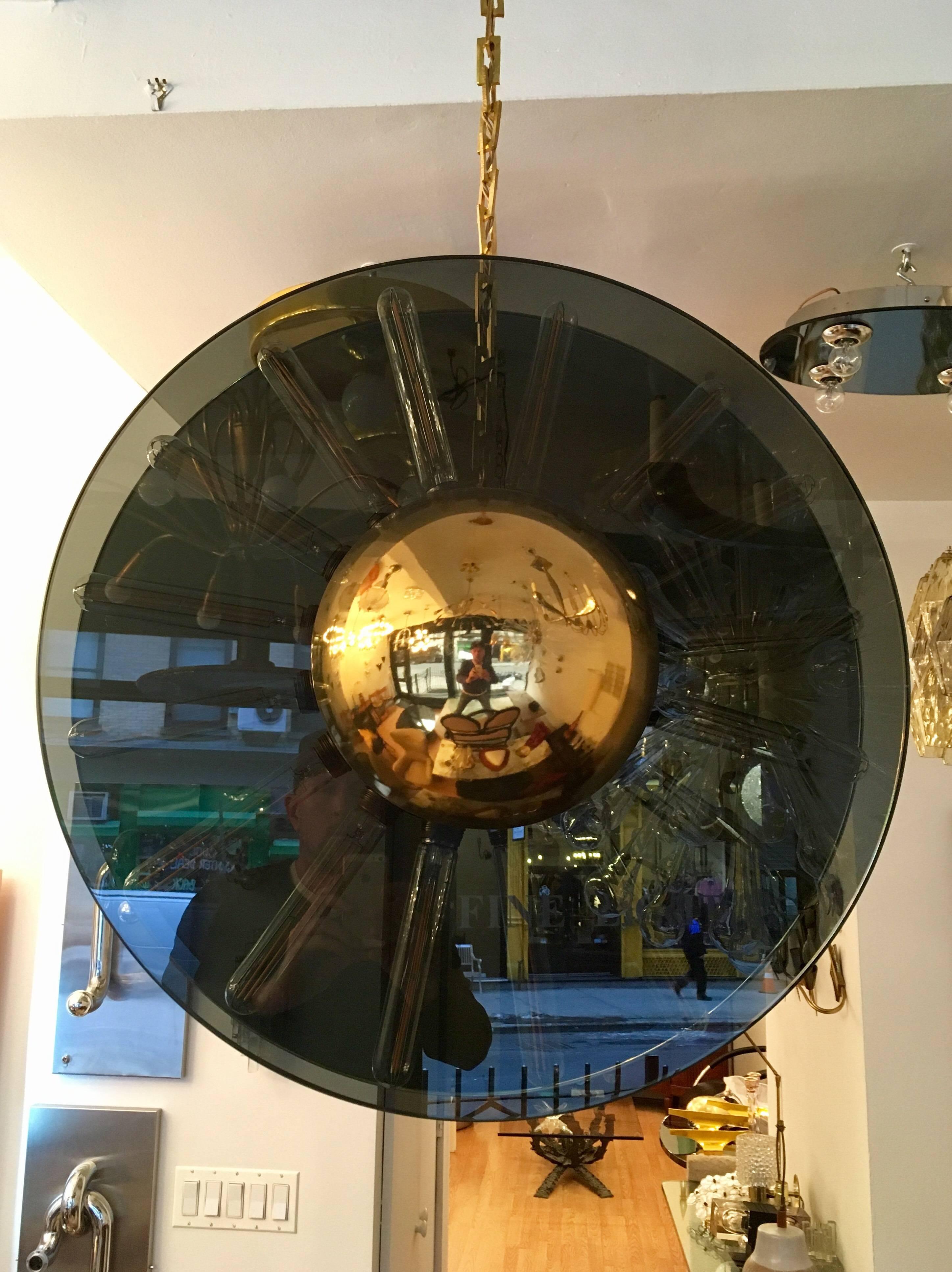 A 1980s Italian pendant of composed of two large half inch thick smoked glass plates and polished brass hemispheres. Newly rewired. Very unusual and unique.