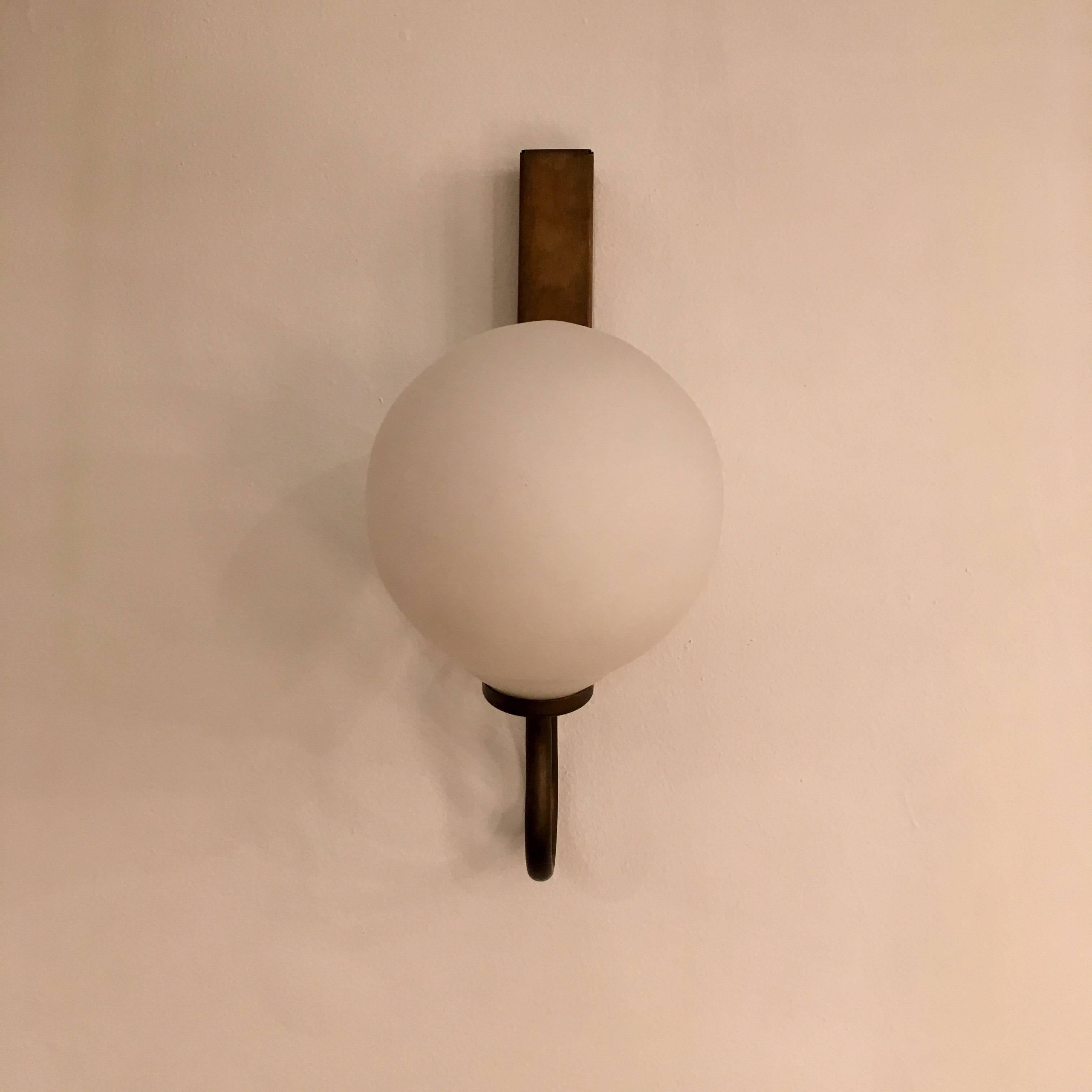 An unusual pair of sculptural 1940s Italian sconces composed of an aged cubed brass holder with frosted glass globe shades. Newly Rewired. Overall height, 13