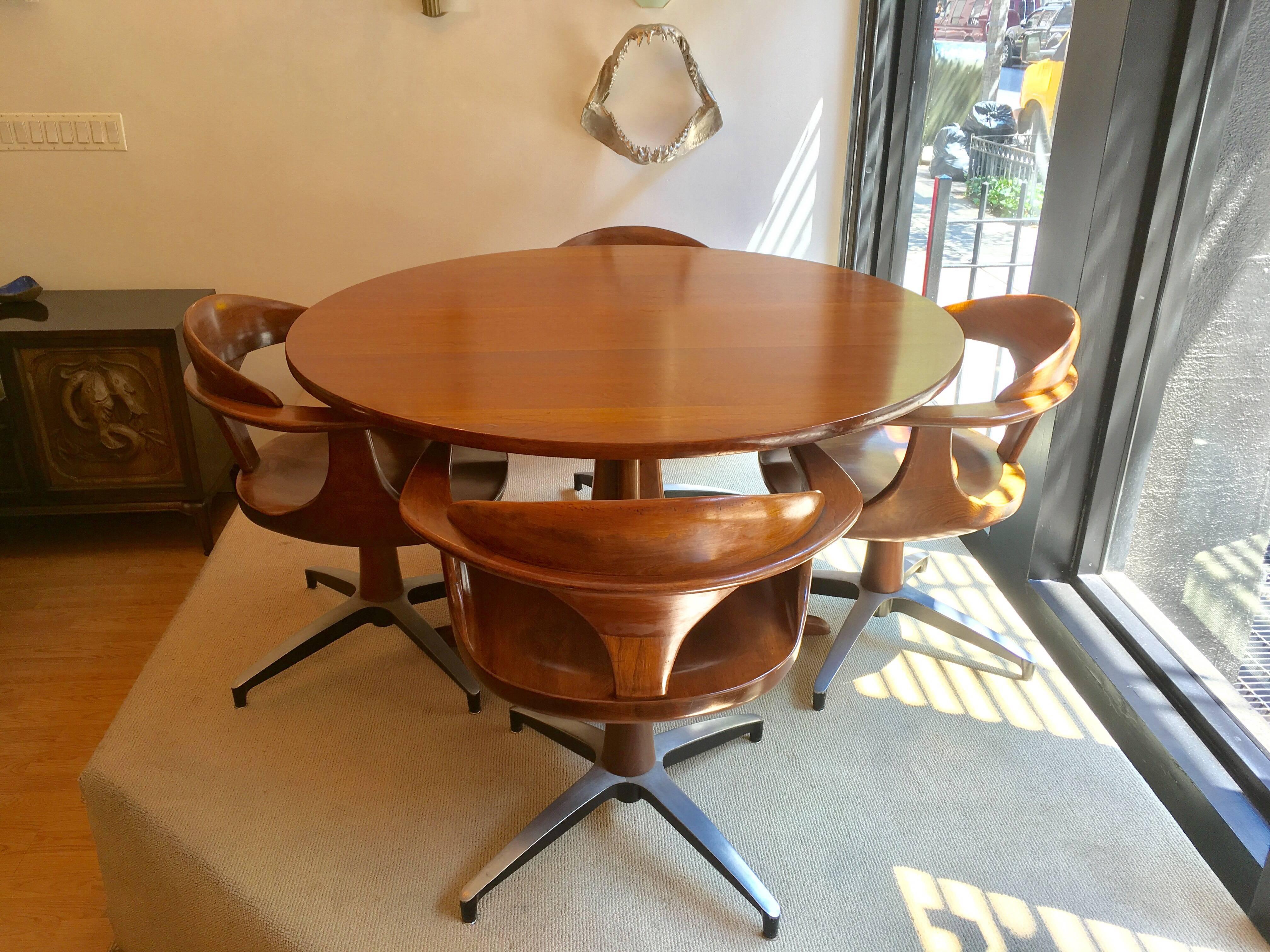 An original American 1960s sculptural hardwood cherry with a medium brown finish and curved Spage Age steel bases. The set of from the famed American furniture maker, Heywood Wakefield, and is part of their last line which debuted in the 1960s,