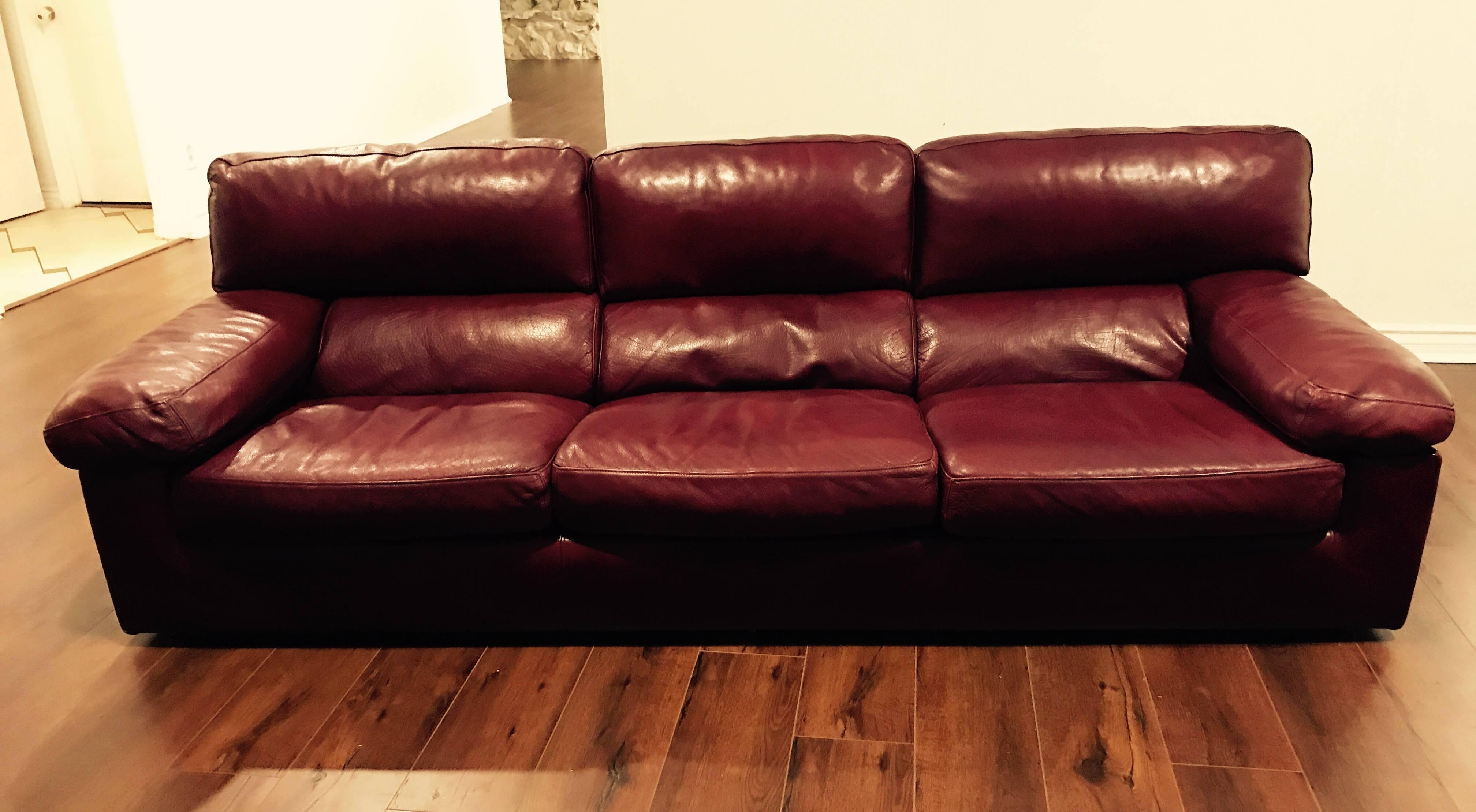 A wonderful 1980s burgundy leather down filled sofa by the French maker, Roche Bobois. It has a great warm patina to the leather and is very comfortable. The high quality bull leather is a oxblood/cardovan color. Matching loveseat available. The
