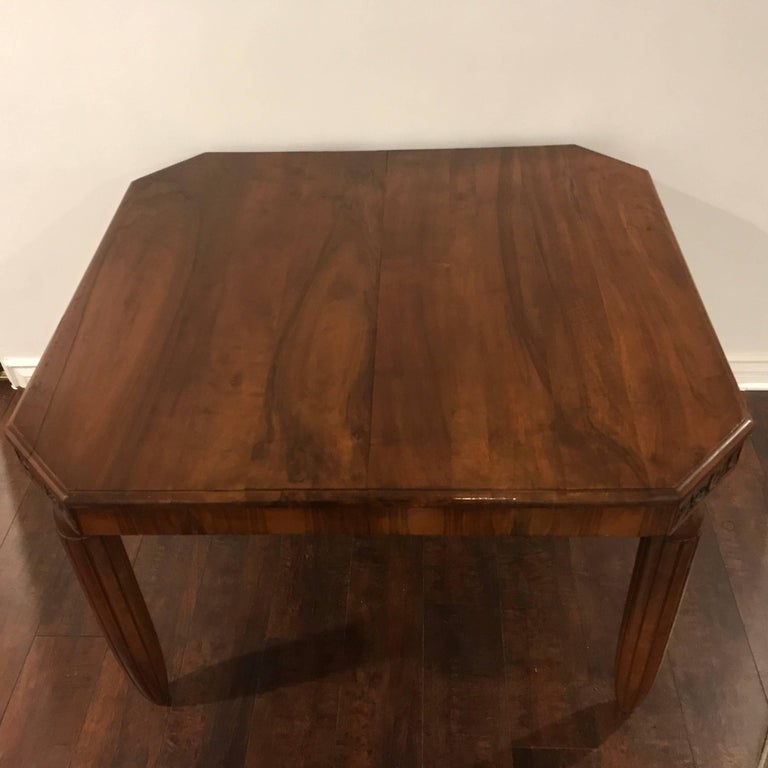 A French Art Deco light to medium walnut table with decorative skirt top and cut corners held with fluted torpedo legs. The table could used for a smaller dining table. Gaming, or centre/ entre use.