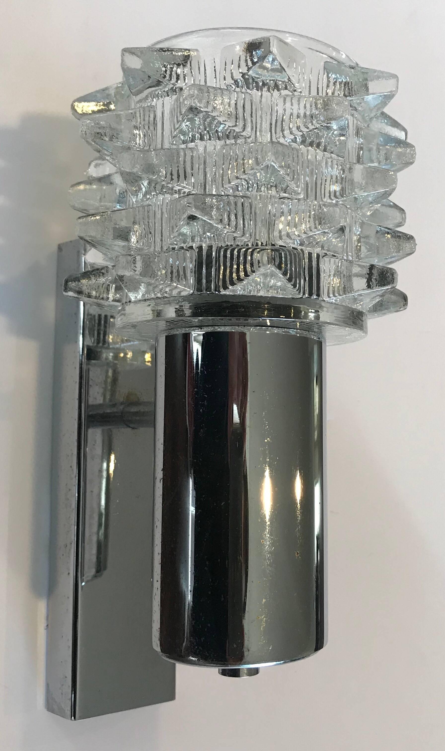 A pair of polished chrome wall lights with heavy crystal glass shades by the Dutch light maker, RAAK. The sconces can be mounted upward or downward according to preference. Four available.