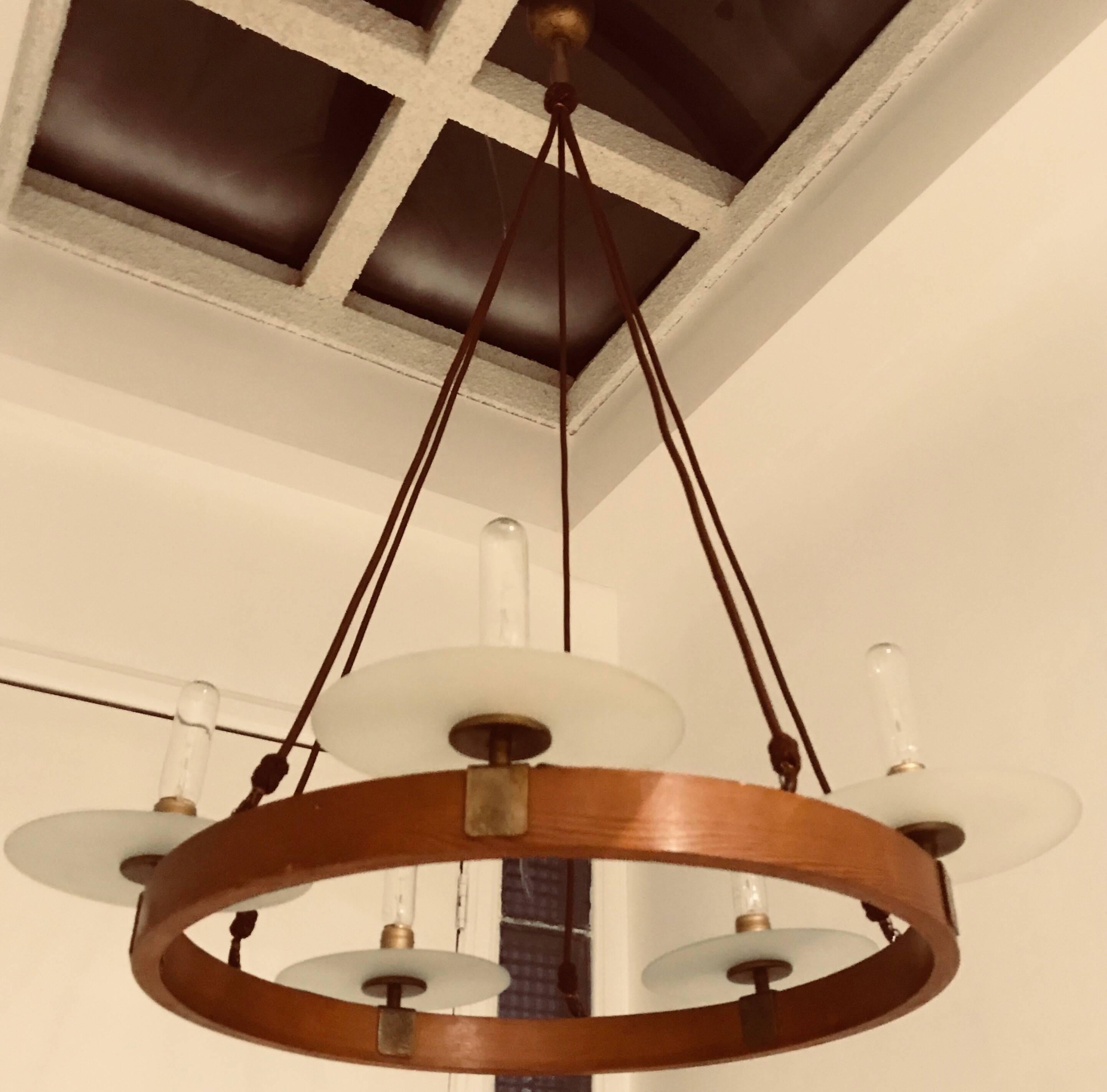 An original 1920s Austrian ring chandelier composed of an oak an brass body with frosted glass disk shades held by brown decorative silk cords . Five lights sources. Newly rewired. Height can be adjusted.