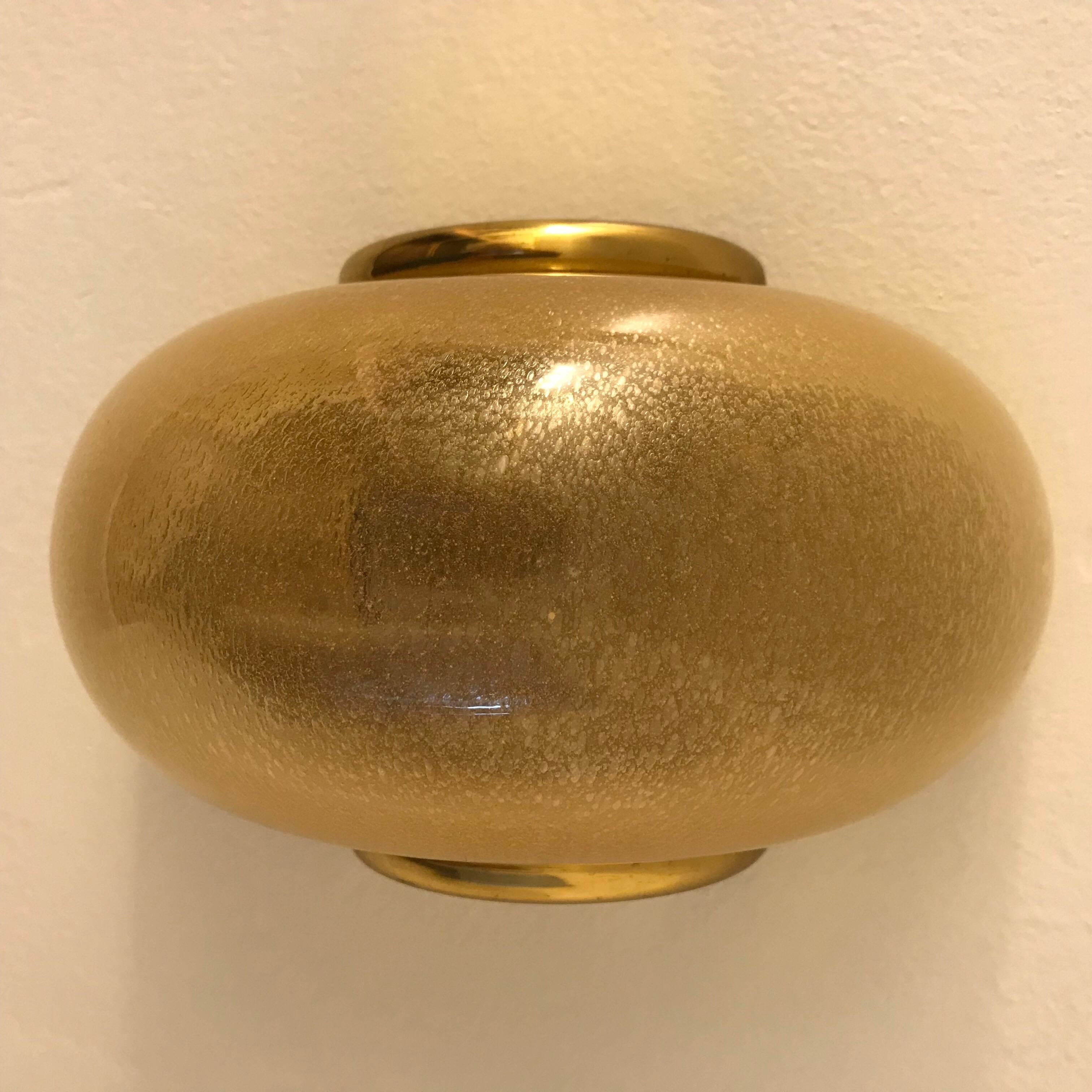 A luxurious set of three, 1980s Italian Murano glass and polished brass wall lights. The thick glass shades have an inset layer gold . The sconces can be hung vertical or horizontal. Newly Rewired . Each contains a standard 100 watt socket.