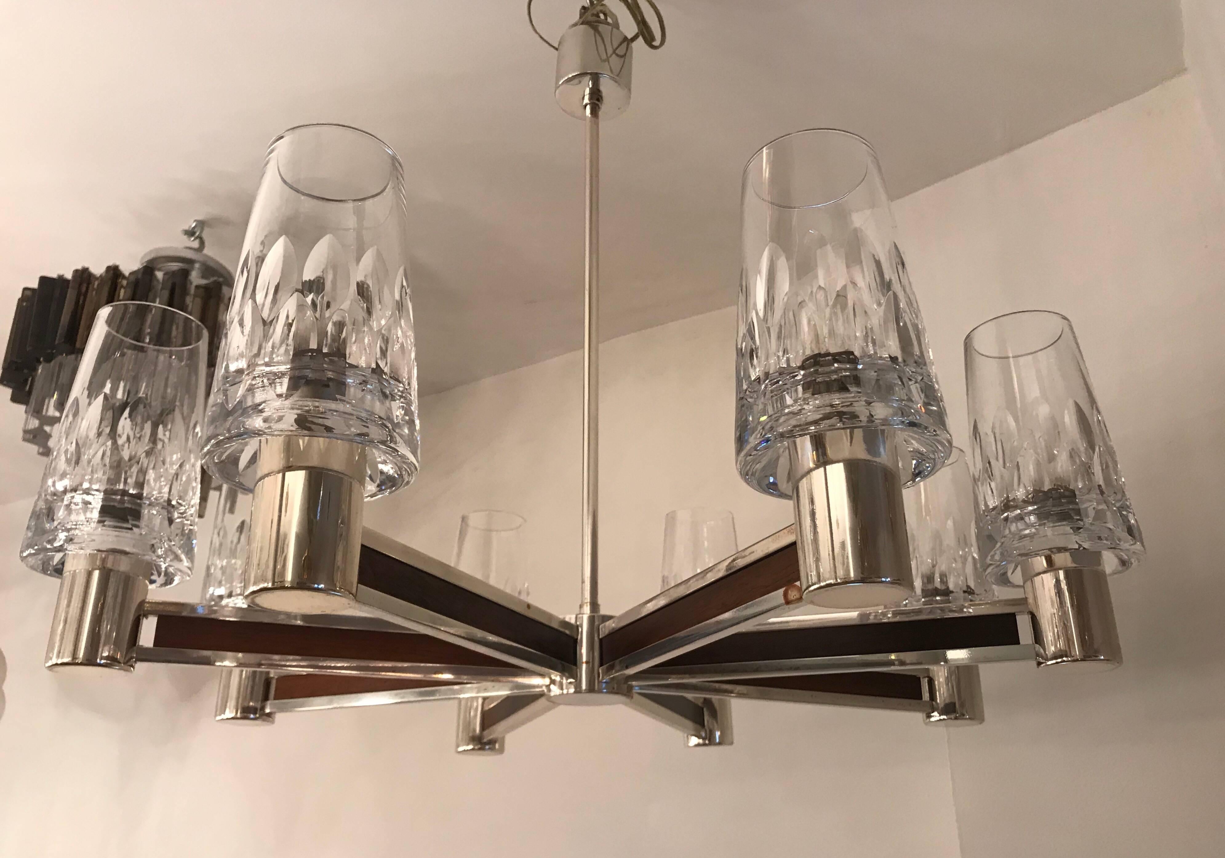 A sleek, 1970s German chrome eight arm chandelier with heavy cut crystal glass shades and walnut decorative accents. Newly Rewired.